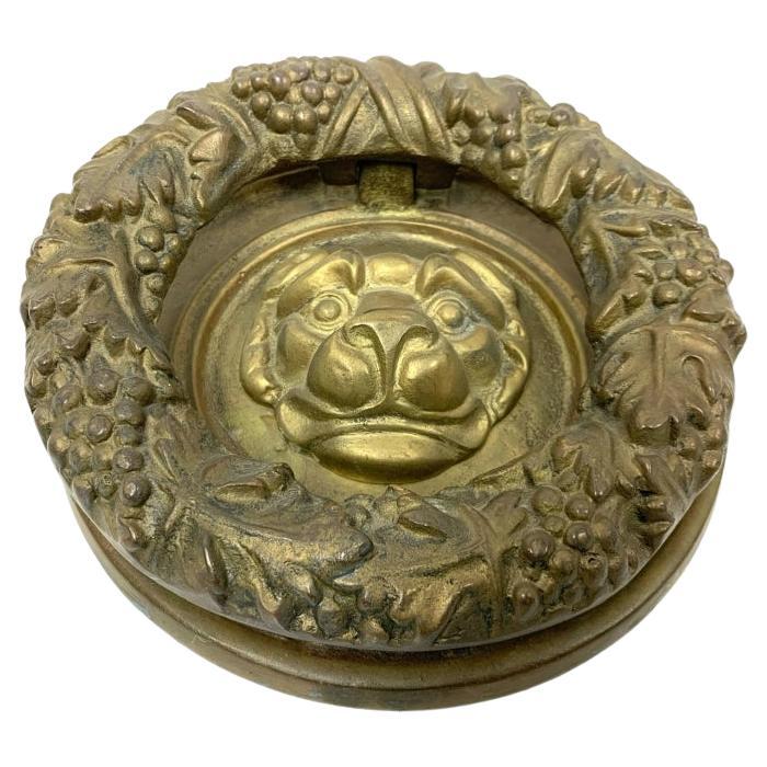 Aldaba de bronce con forma de cabeza de león