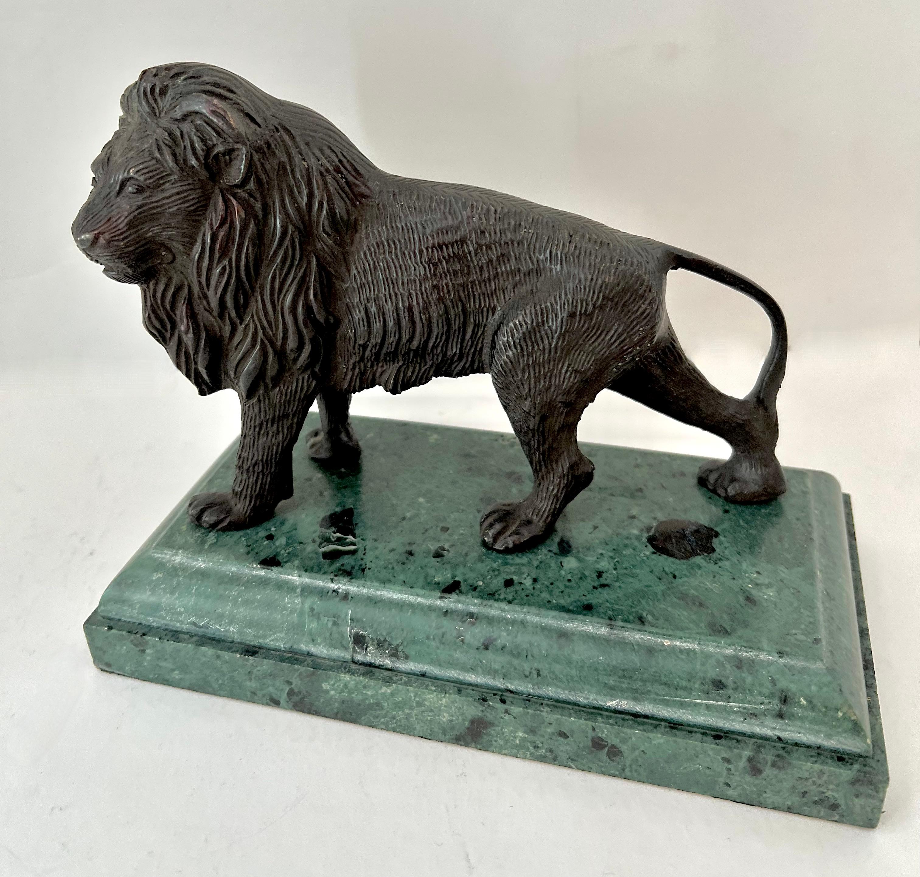 A bronze Sculpted Regal Lion on a Marble base.  This is a lovely piece that could be a stand alone decorative piece or also used as a bookend or paperweight.