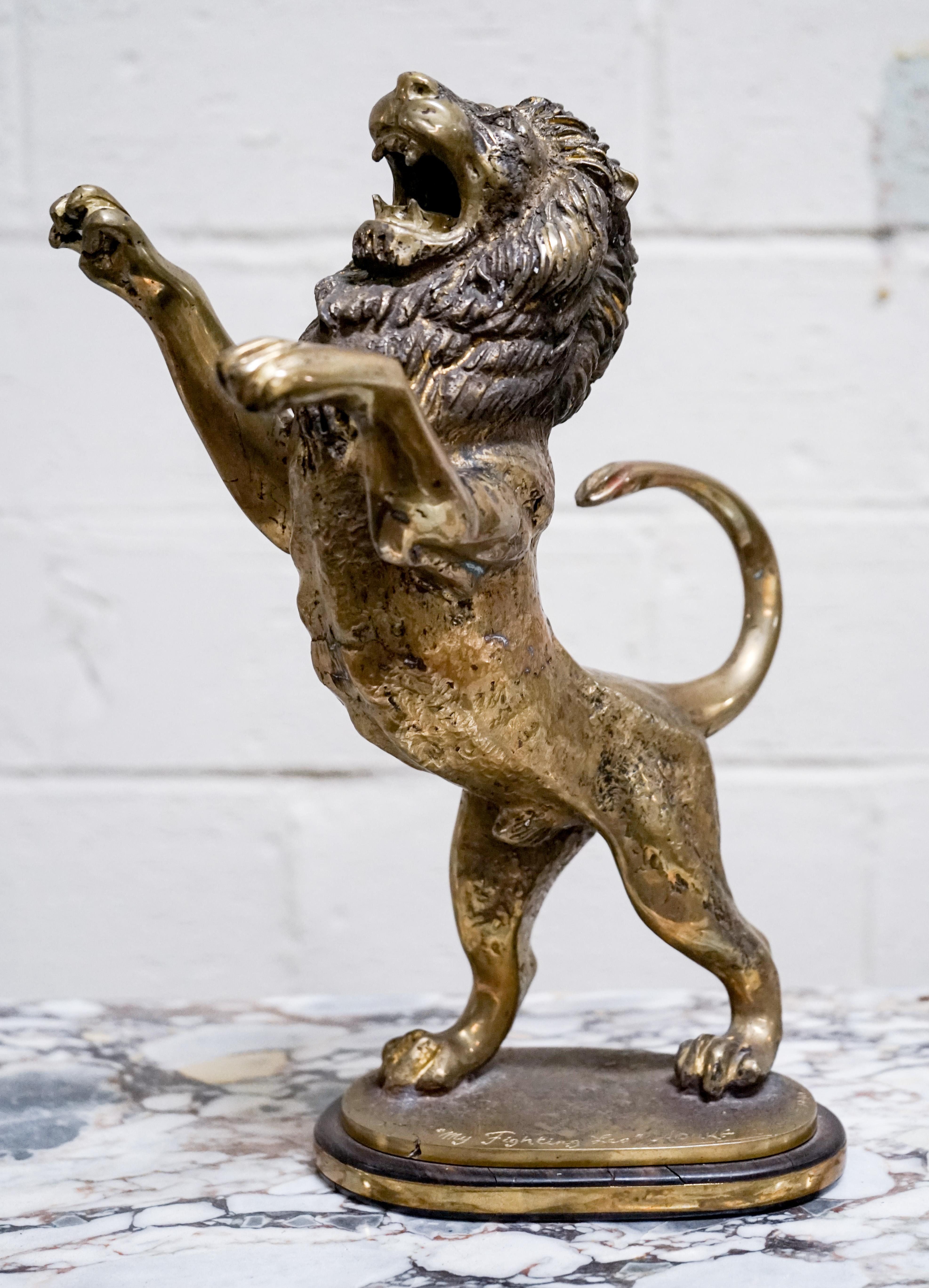 This bronze sculpture of a lion stands a foot tall and makes for an excellent piece for a library or study. Signed and dated by the artist 'Aouke' in 1990 in Zaire.

Measurements: 12.5'' H x 10'' W.