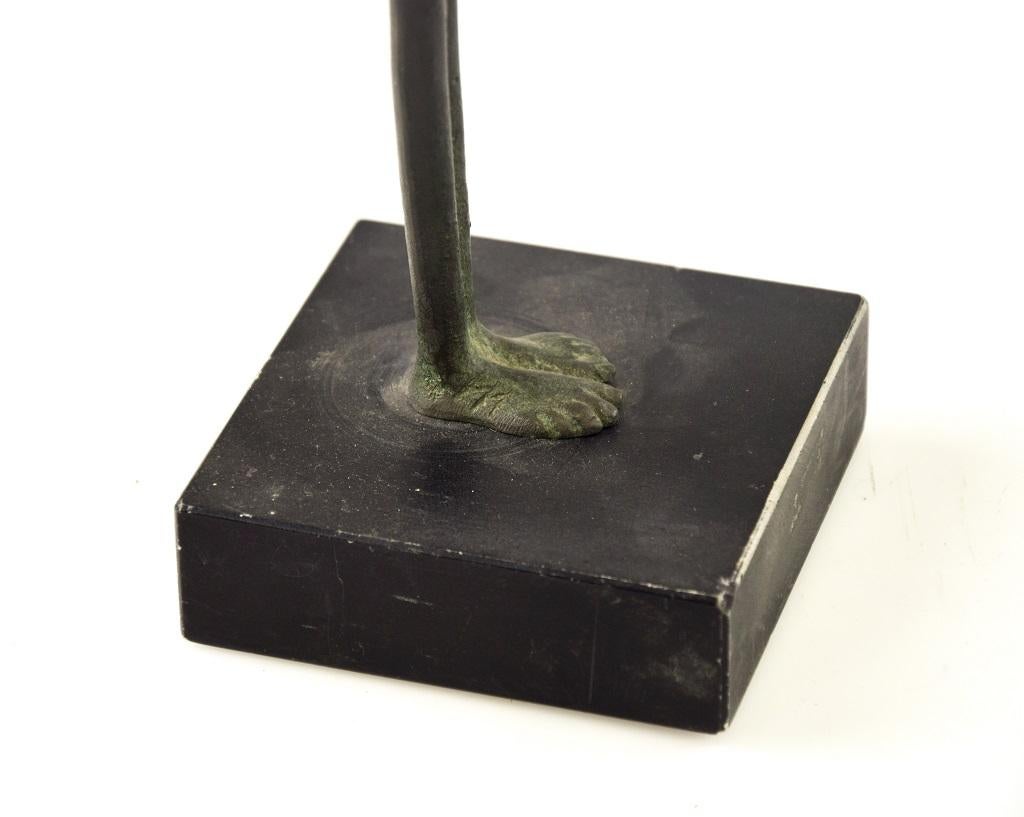 La statua di bronzo maschile è una scultura in bronzo patinato verde con base in legno che rappresenta un uomo filiforme. Di un artista sconosciuto, un emulatore italiano di Giacometti in chiaro stile esistenzialista.

Firmato con il piede giusto.