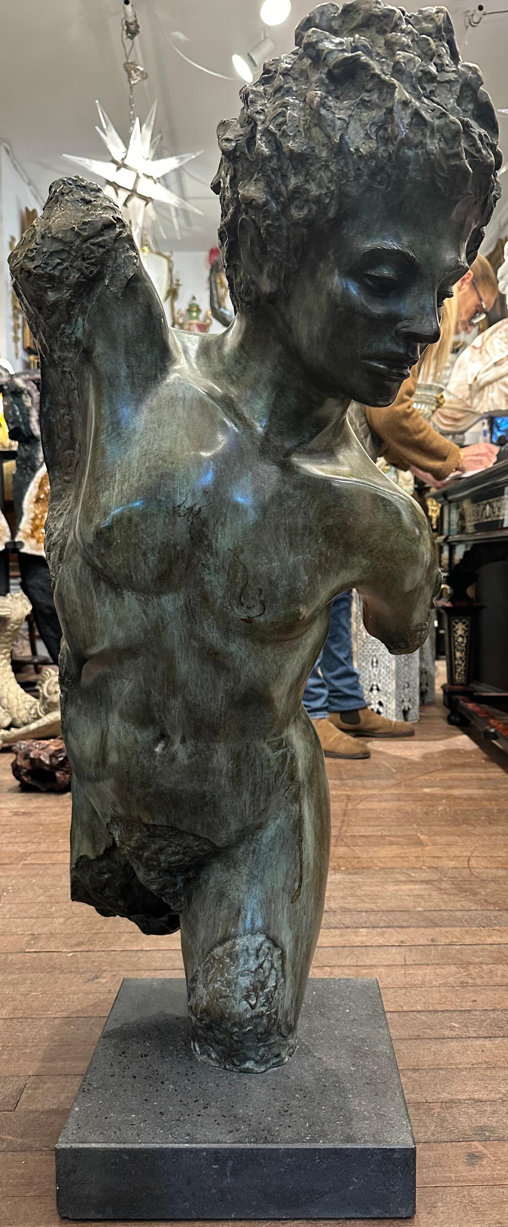 A attractive, stylised bronze casting of a male torso, on a black marble base.The face is detailed and skilfully done. The male torso is part polished and part textured with a decorative aged verdigris patina. The ruffled hair contrasts against the