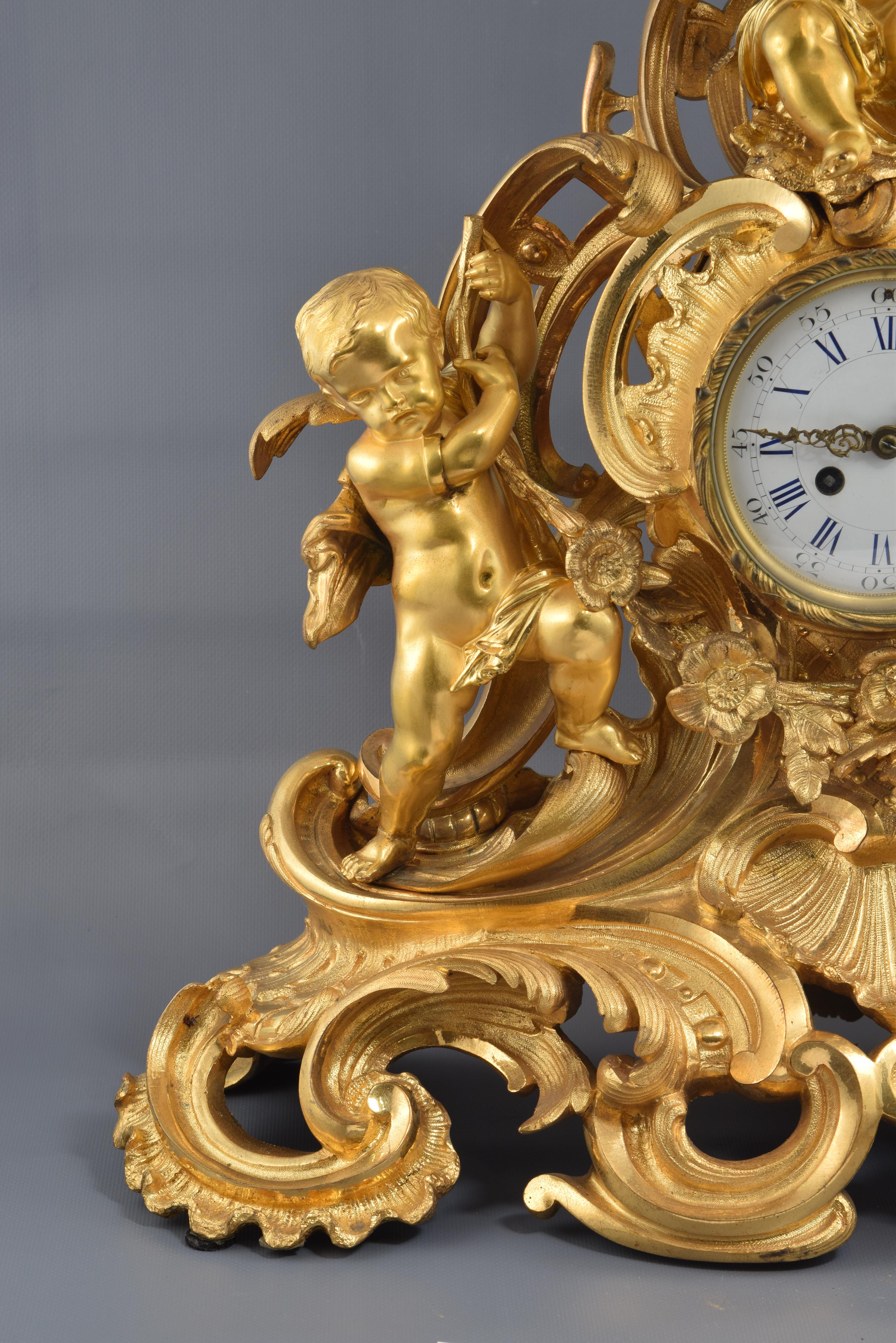 Table clock. Bronze, 19th century.
Table clock made of gilt bronze featuring a white dial with Roman numerals for the hours and Arabic numerals every five for the minutes, Louis XV hands and a golden frame around. On a base that combines pebbles