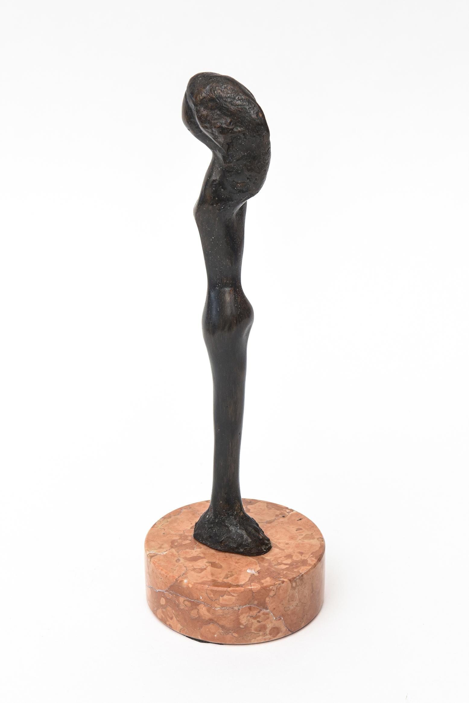 This sensual abstract small bronze Mid-Century Modern bronze sculpture sits on its original marble base. It is signed but not legible even with a macro lens. It is of a female abstracted form. The color of the orange veined original marble is a