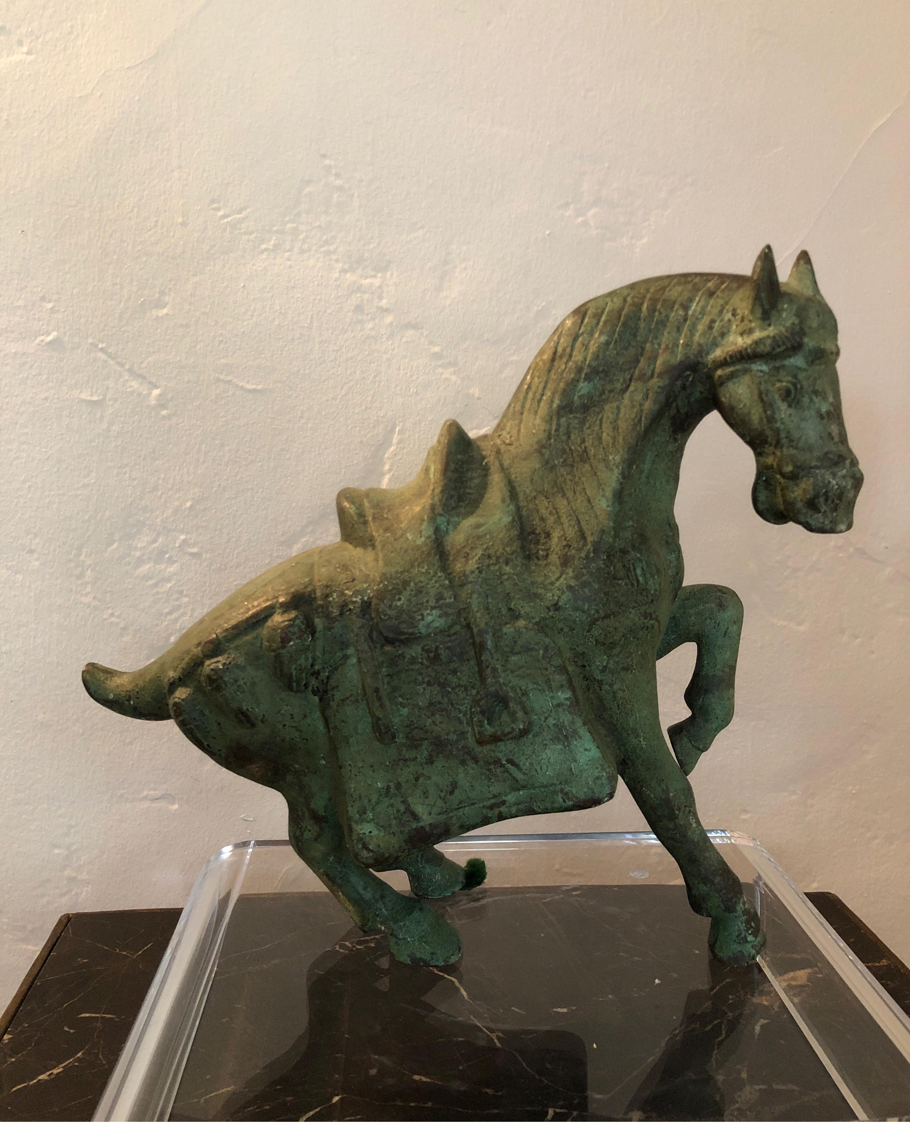 Vintage bronze dynasty horse statue with green patina. 
Horse is in standing position with leg raised and body/head ready to raise.
