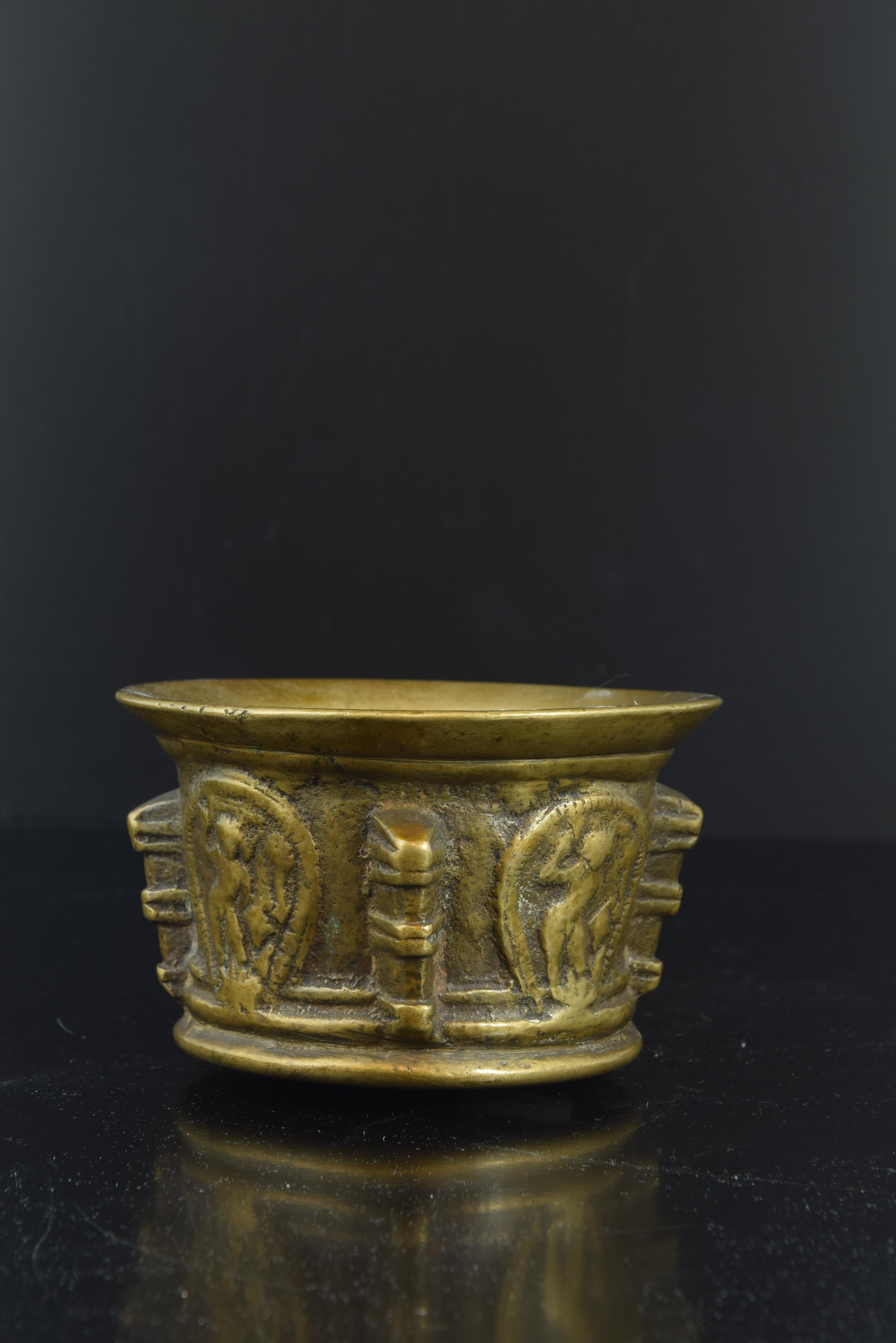 Mortar in bronze of the 17th century, decorated with ribs in the form of pillared pilasters and, in the planes, cartouches with the representation of Saint Michael the Archangel in relief.
Size: 7 x 7 x 12 cms.