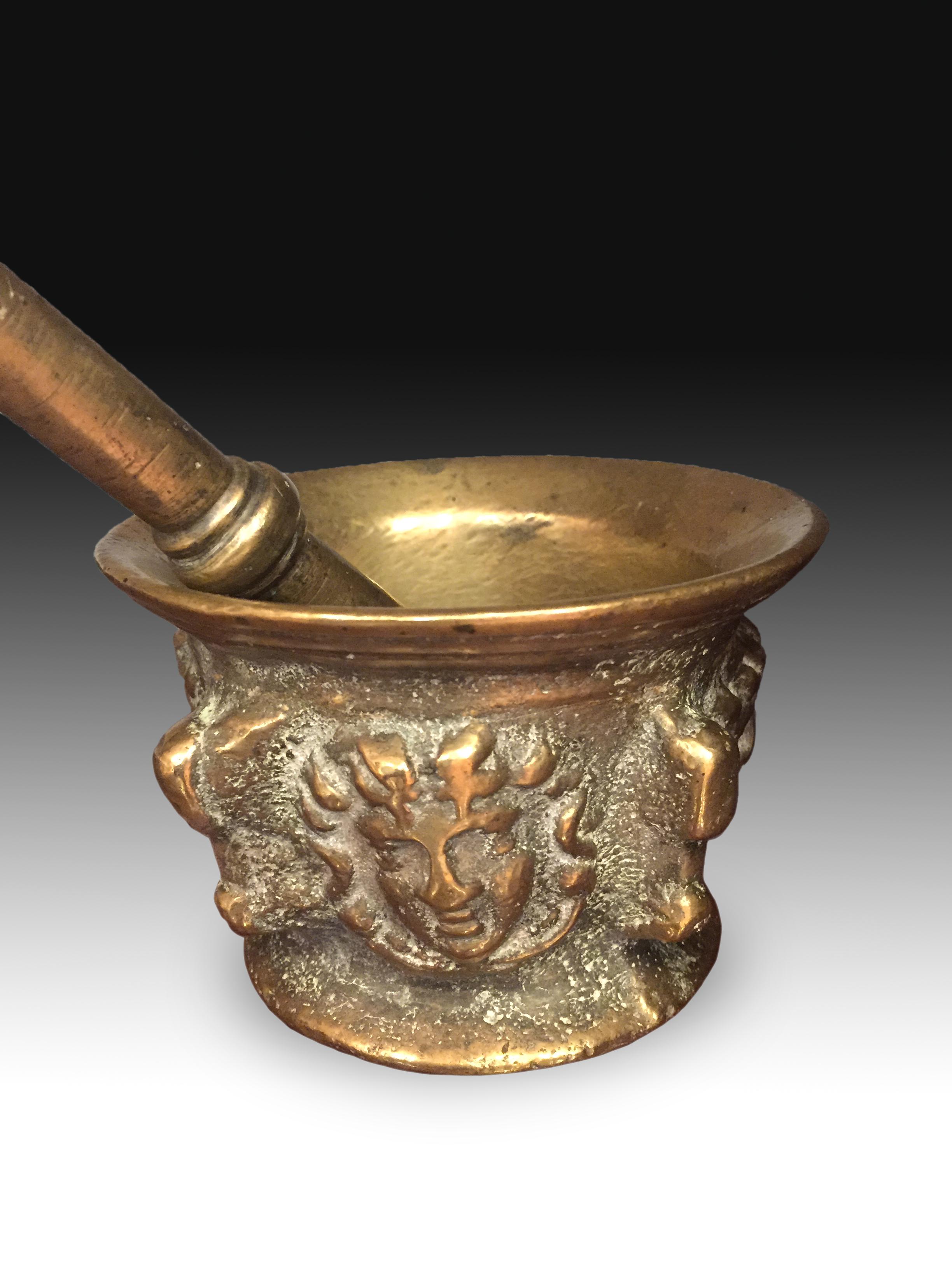 Bronze mortar, 17th century.
Mortar with a cylindrical body with an open mouth towards the outside and a prominent lower molding that presents a decoration based on ribs with relief masks. This type of works were created for use in pharmacies or in