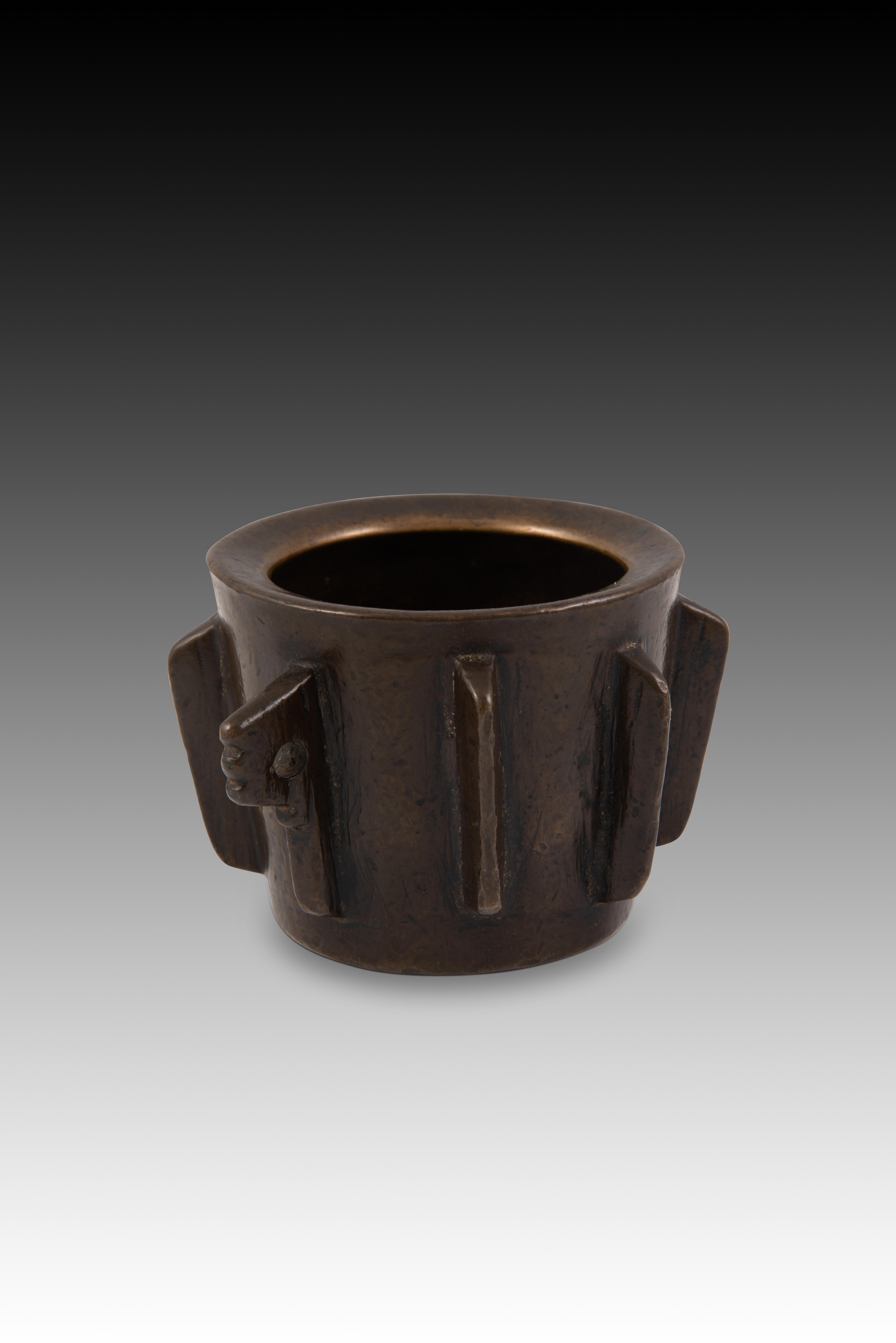 Ribs mortar. Bronze. Spain, 16th century. 
Cylindrical bronze mortar with two geometrically shaped handles on the sides and a series of “ribs” on the outside, rectangular and pointed. Due to the shape and decorative elements, this piece has been