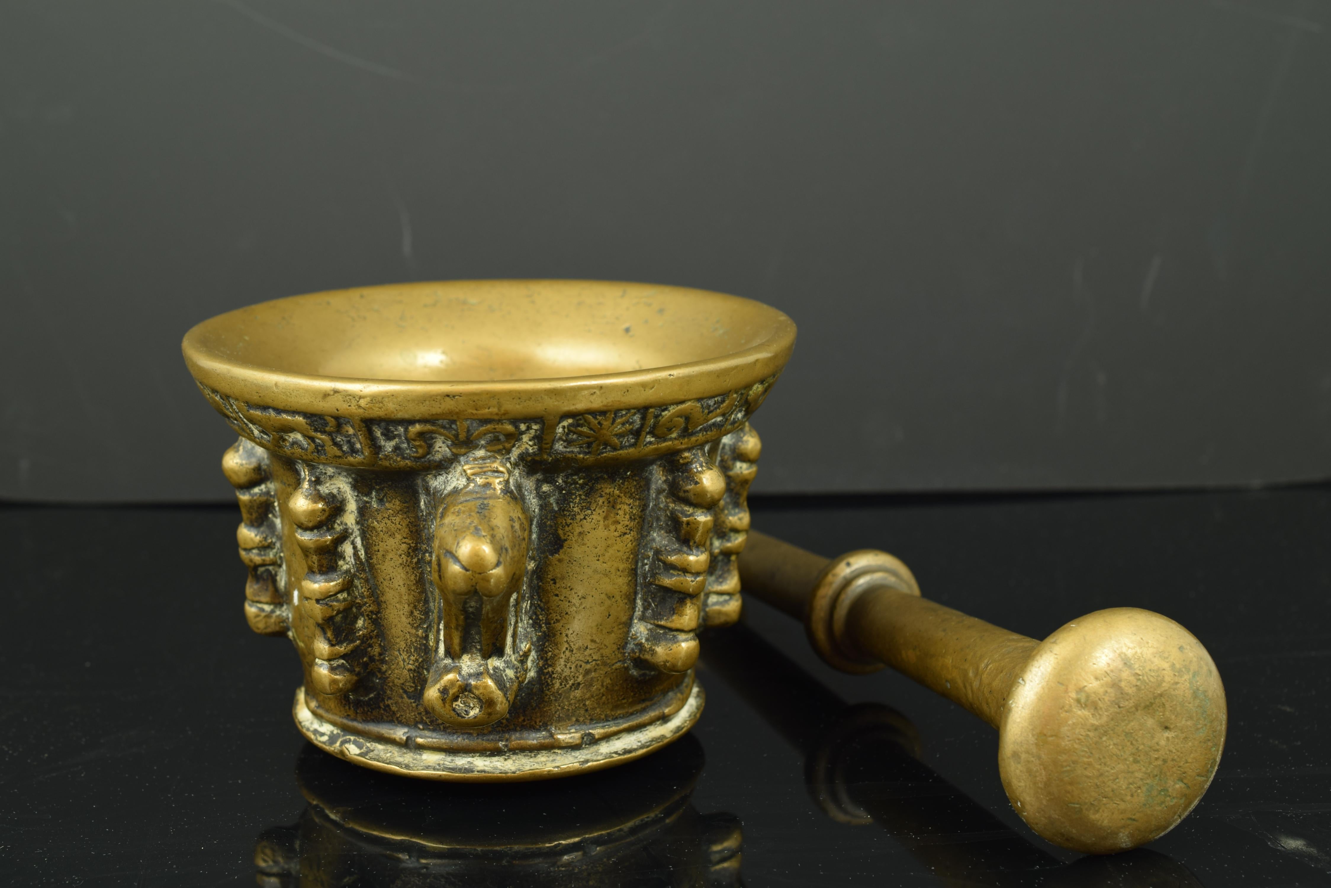 The mortar presents decoration in relief based on ribs, pearls and columns, two handles and an upper band with vegetal elements and stars, as well as two handles. The pestle, of circular section and smooth shaft, shows a central semicircular molding