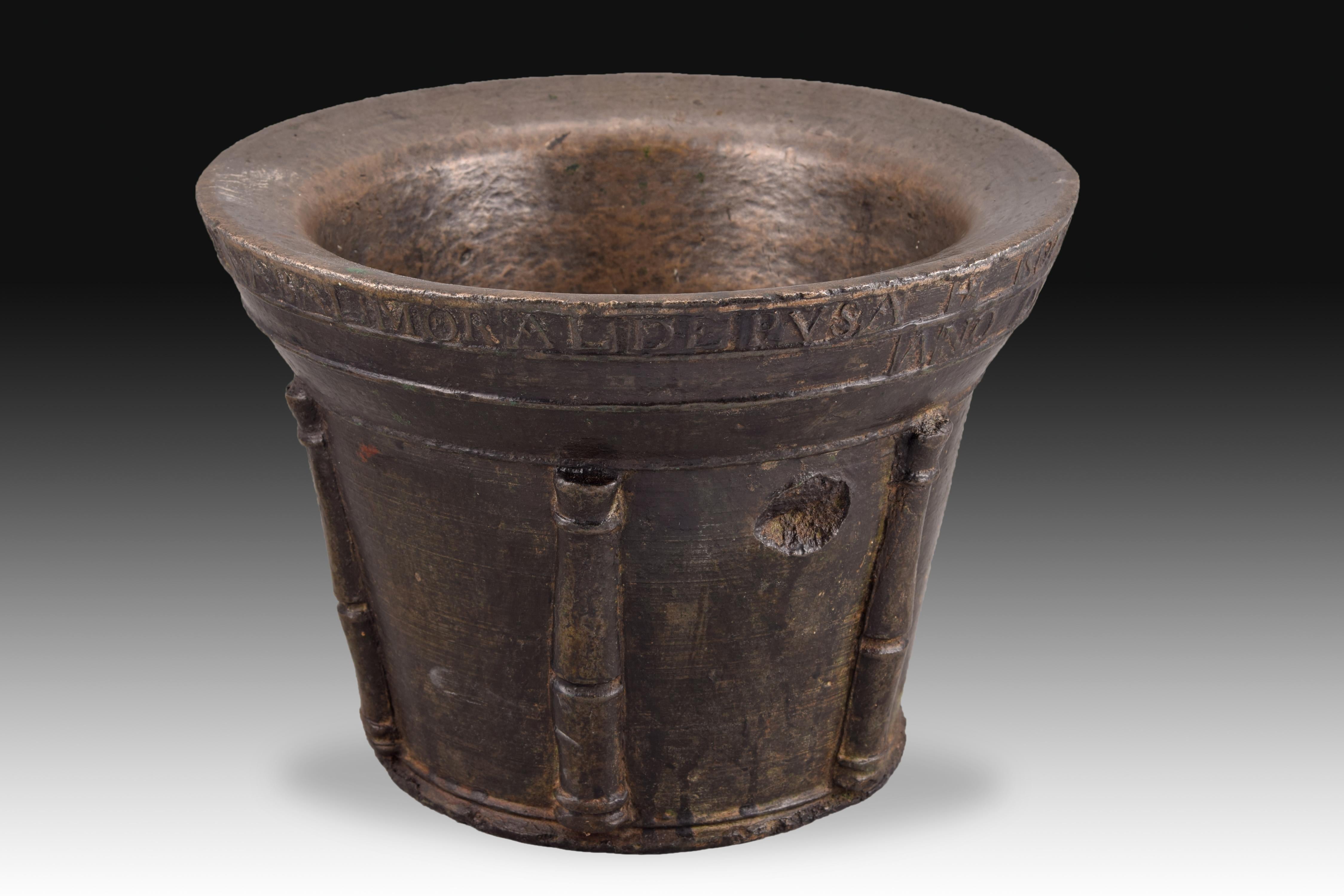 Pharmacy mortar. Bronze. Spain, 1816. 
Mortar with an excavated mouth, decoration of derived ribs in pilasters and a stripe in the upper area with an inscription (I am from Don Juan Antonio Martínez apothecary in Nabalmoral de Pusa / Year 1816);