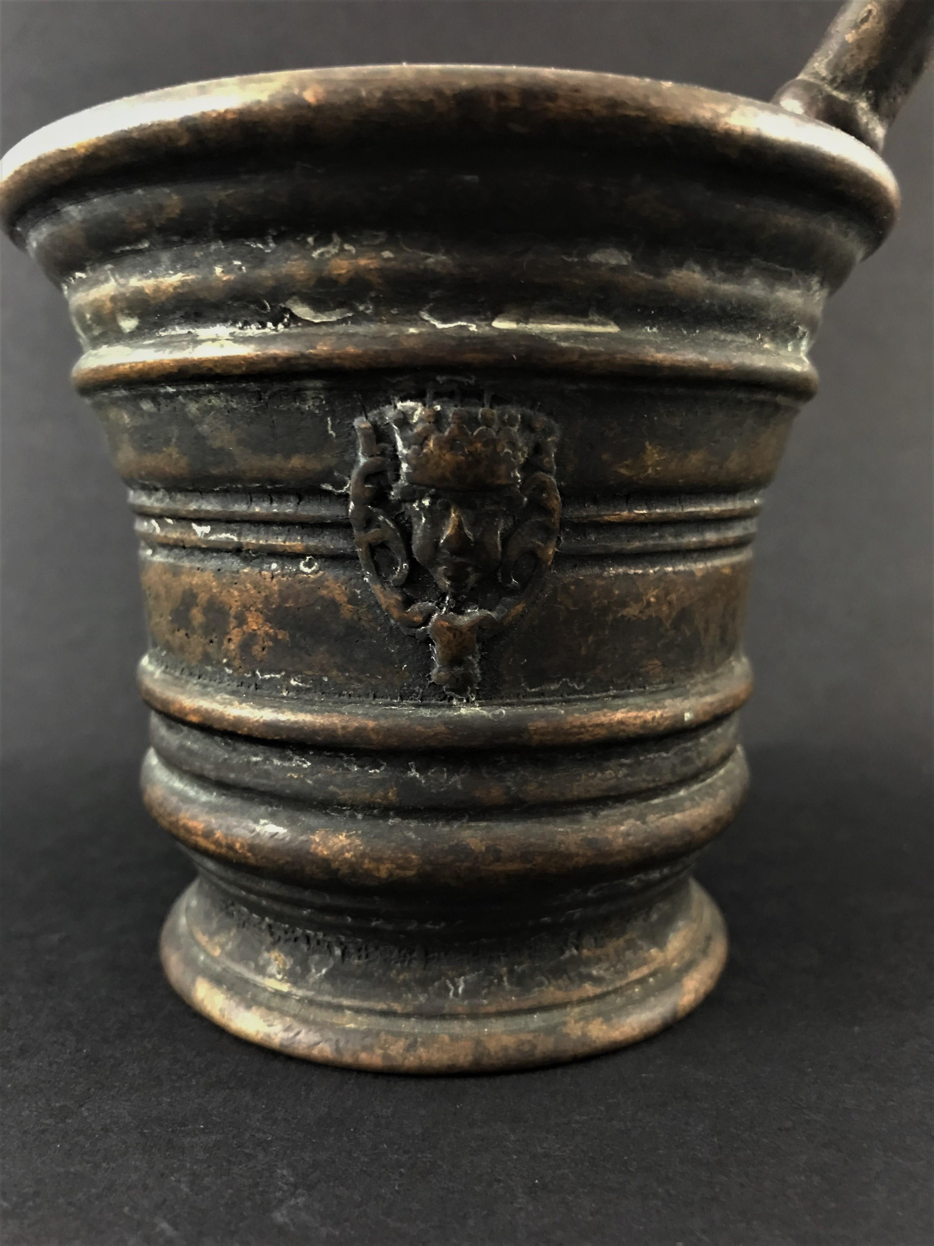 Mortar decorated with a mascarons and pestle, patinated bronze, early 20th century.
Measures: Height mortar 4 inches
Height pestle 7 inches.
 
