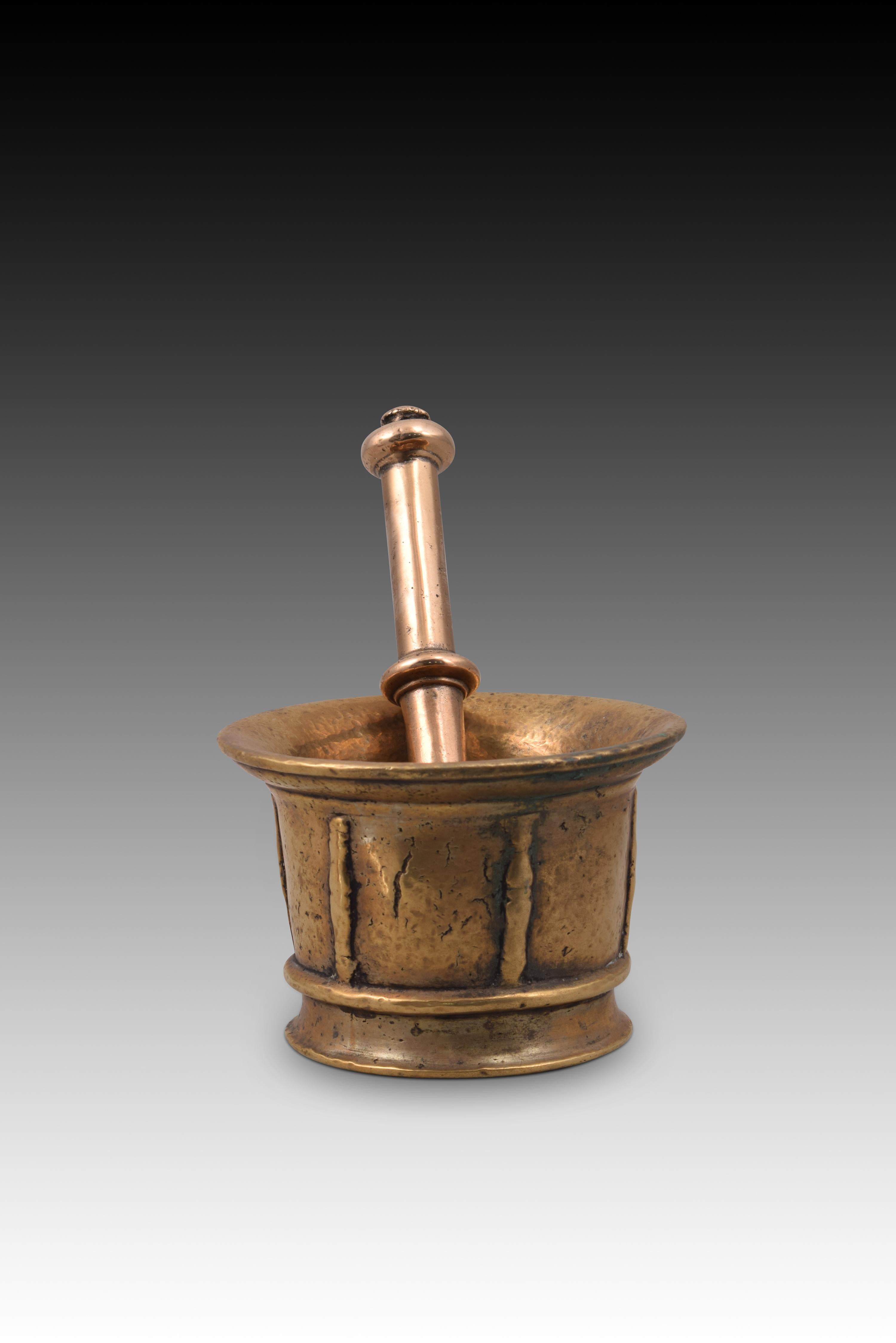 Mortar with hand. Bronze. XVII century. 
Mortar with a circular base, cylindrical body and slightly outwardly flared mouth, decorated with a series of smooth horizontal moldings arranged both in the lower and upper areas and with simple vertical