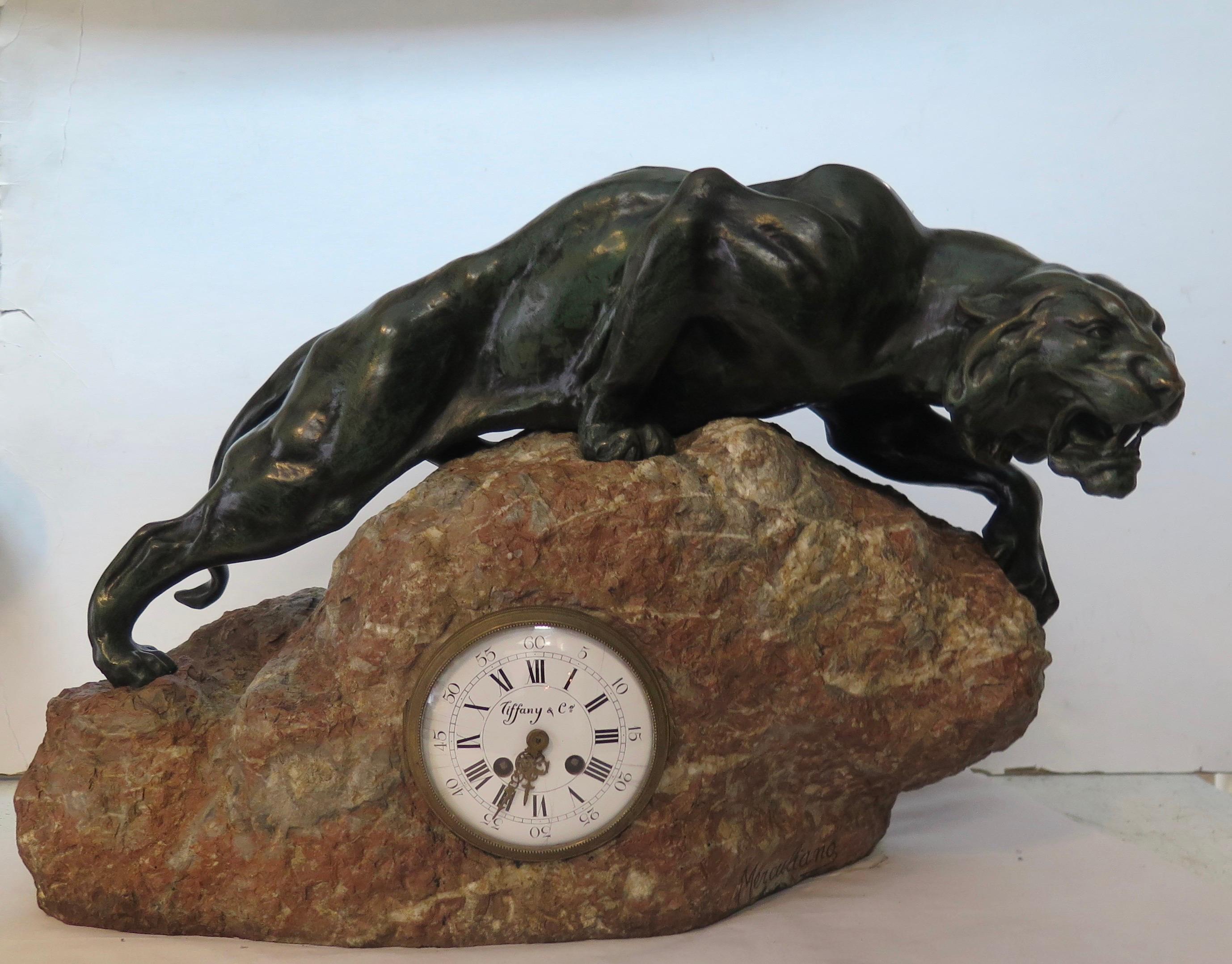 Cette majestueuse sculpture animale en bronze et cette horloge datent du début des années 1900. La sculpture a été créée et signée par l'artiste MERCULIANO. L'étonnante sculpture en bronze patiné vert foncé d'un lion de montagne présente un corps