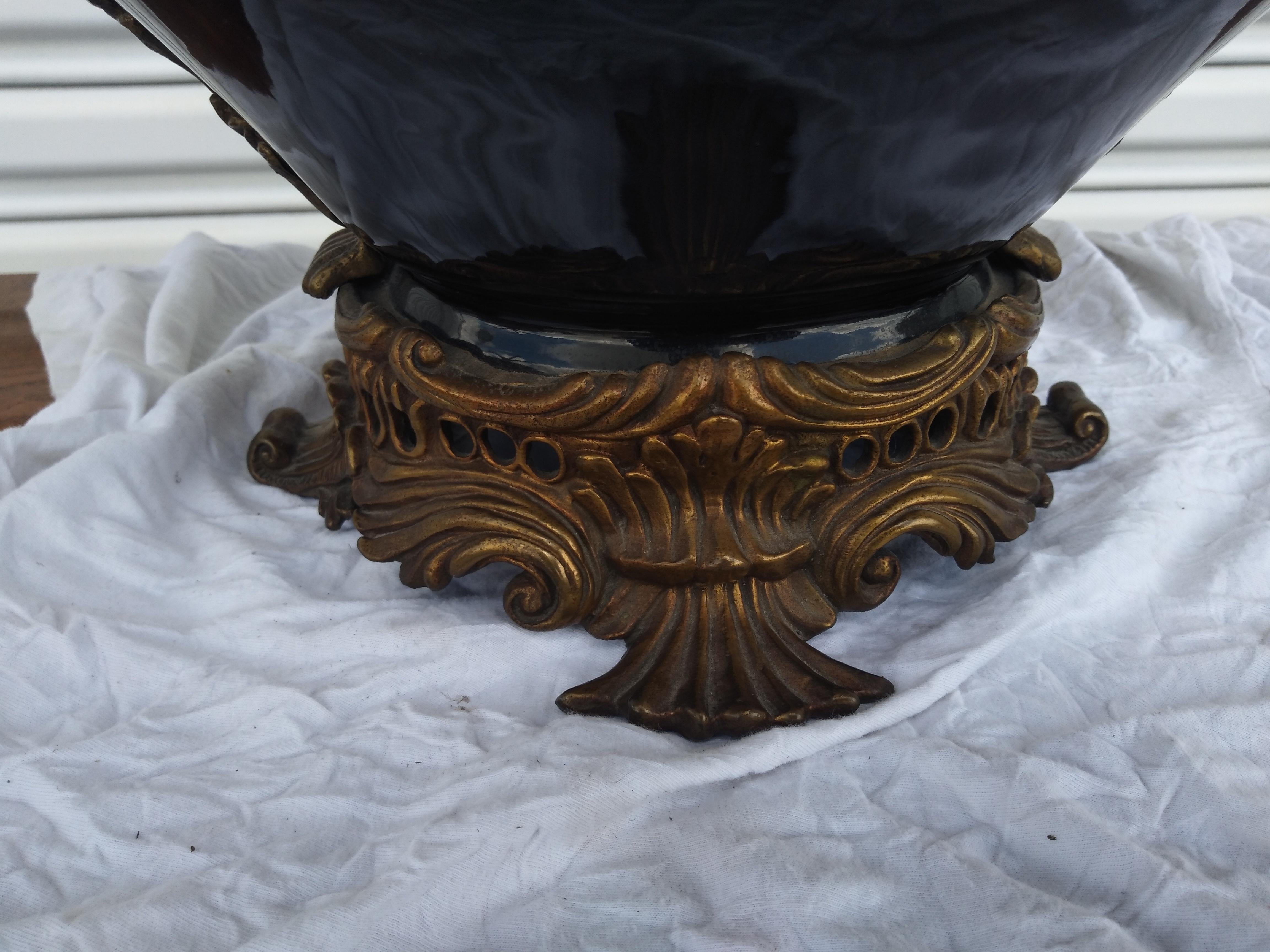 Il s'agit d'un magnifique centre de table de style Castellan avec des poignées en bronze. Les anses et le bord sont percés. Le bol bleu cobalt est en porcelaine. La pièce centrale repose sur un socle en bronze sculpté.

Une belle addition à votre