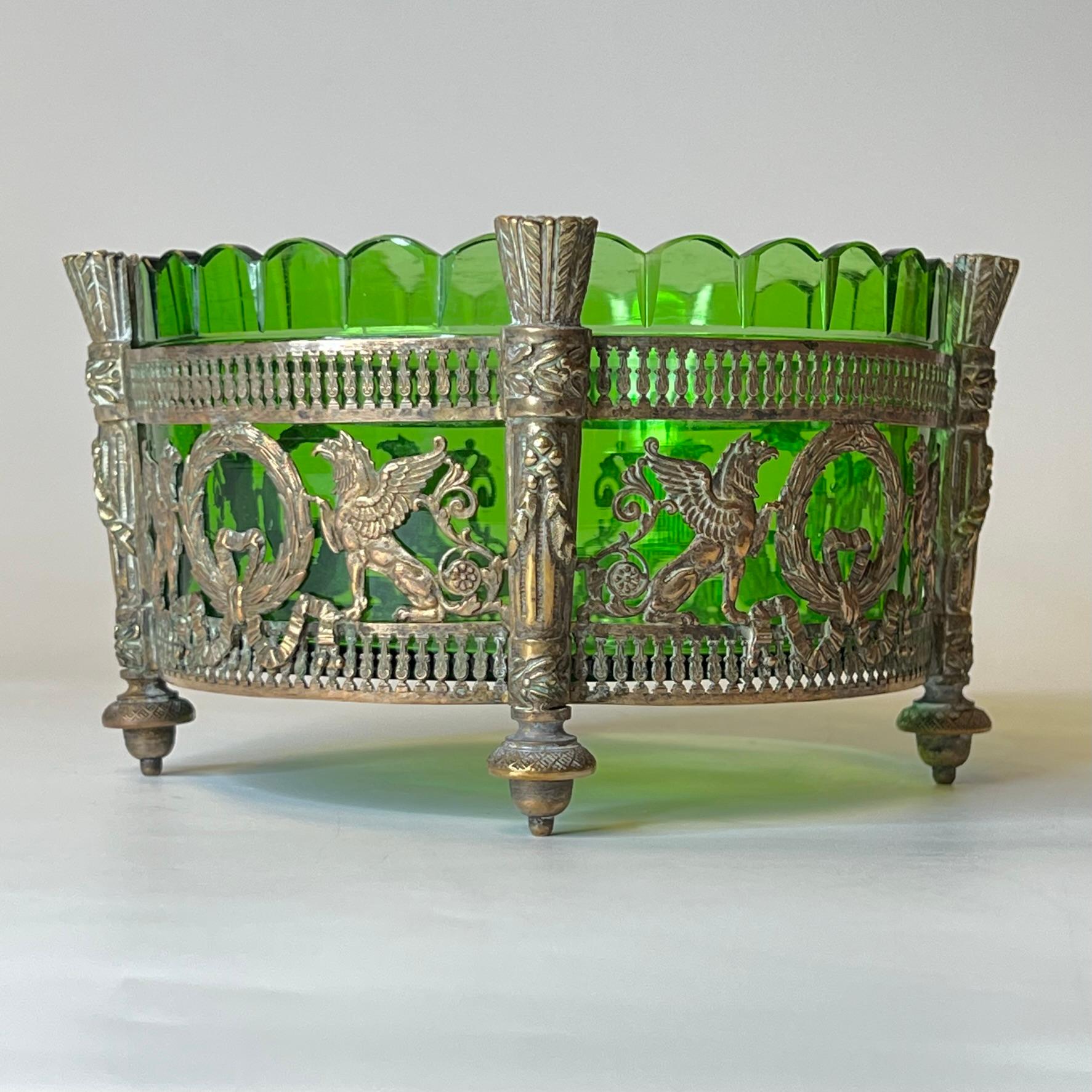 Exceptional bowl crafted from cut green glass with finely cast bronze mounted frame with neoclassical motifs, including wreaths, griffins and torches.  In very good condition.  One small chip loss to the rim of the glass.  Apparently unsigned.