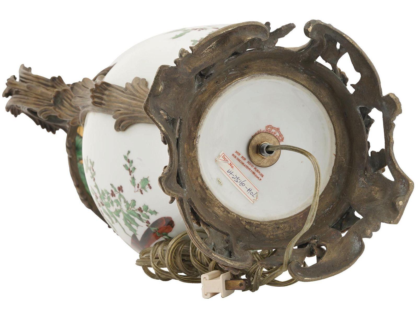 Vase en porcelaine avec des montures en bronze à feuillage élaboré dans le style Louis XV avec des oiseaux finement peints avec des plumes rouges perchés sur des branches de houx avec des baies,  et un motif de feuilles vertes répétées, avec dorure