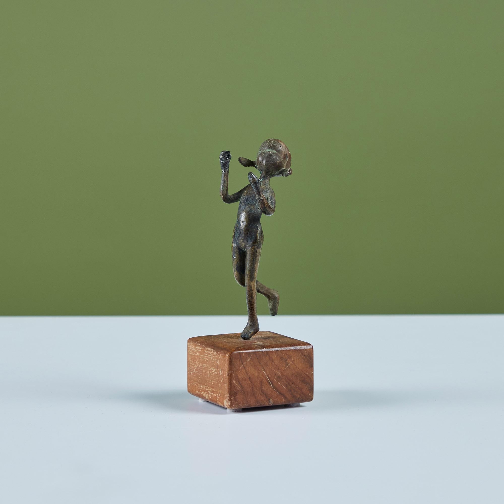 Sculpture en bronze coulé d'un enfant avec des nattes montée sur une base en bois.

Dimensions
2,5