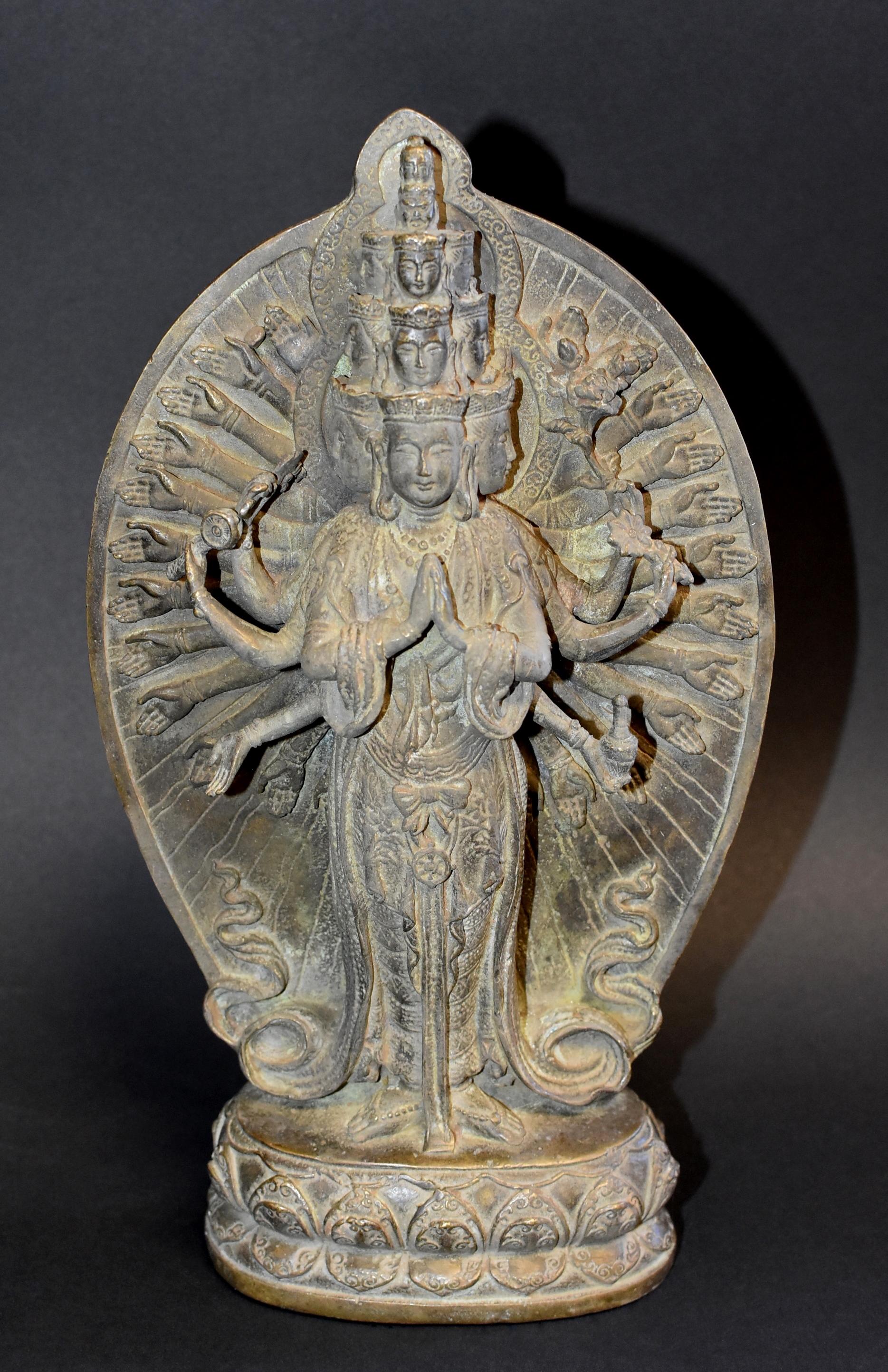 A most exquisite bronze Multiple Headed and Armed Avalokitesvara Guan Yin statue. Standing on double lotus throne with the main pair of hands held in the gesture of respectful salutation, 