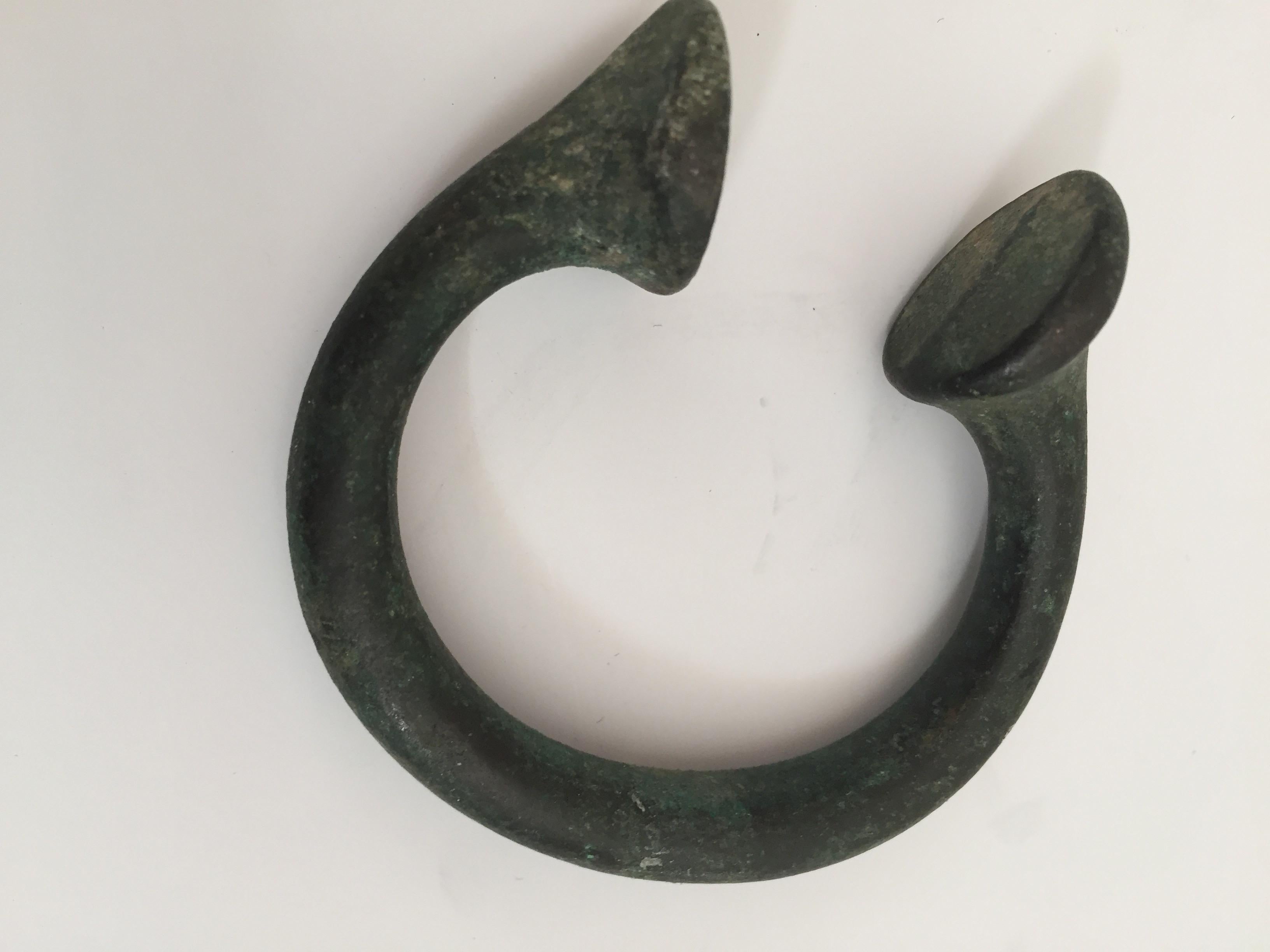 Antique bronze Okpoho-type manilla currency from south-eastern Nigeria.
Manillas (which were a traditional African exchange medium) were originally metal bracelets or armlets. Later forms were made of copper, bronze, or brass open rings (penannular