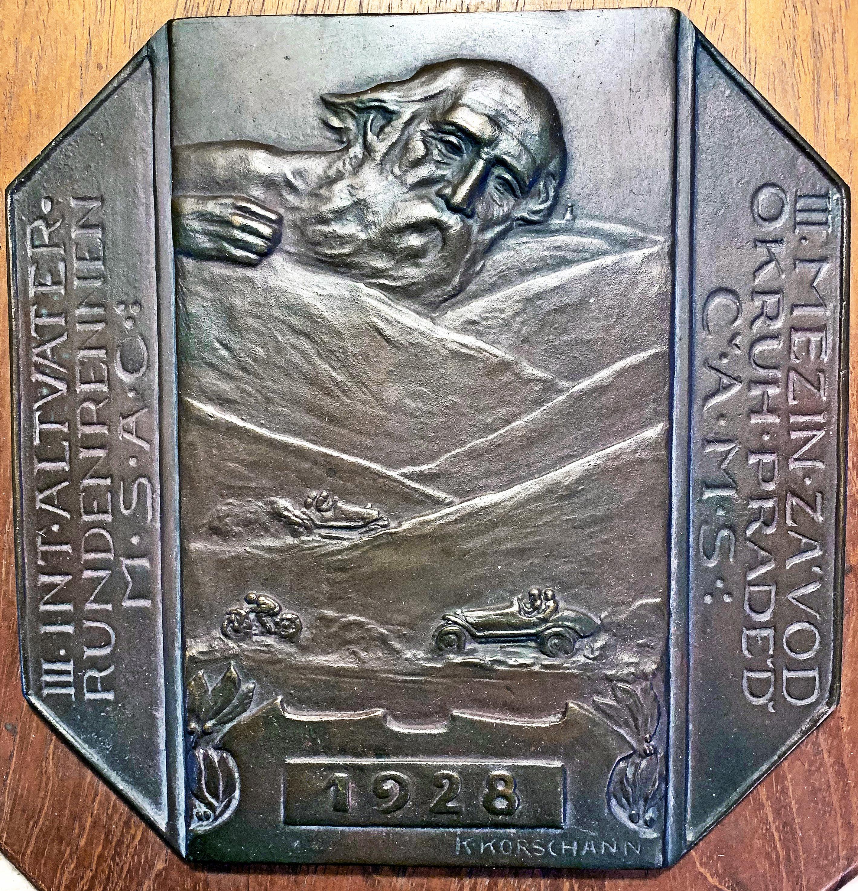 A very rare, perhaps unique, example of early automobiliana, this 1928 bronze panel, sculpted by Charles (or Karl) Korschann, celebrated one of the earliest road races in Europe, which at the time included both race cars and motorcycles. The race