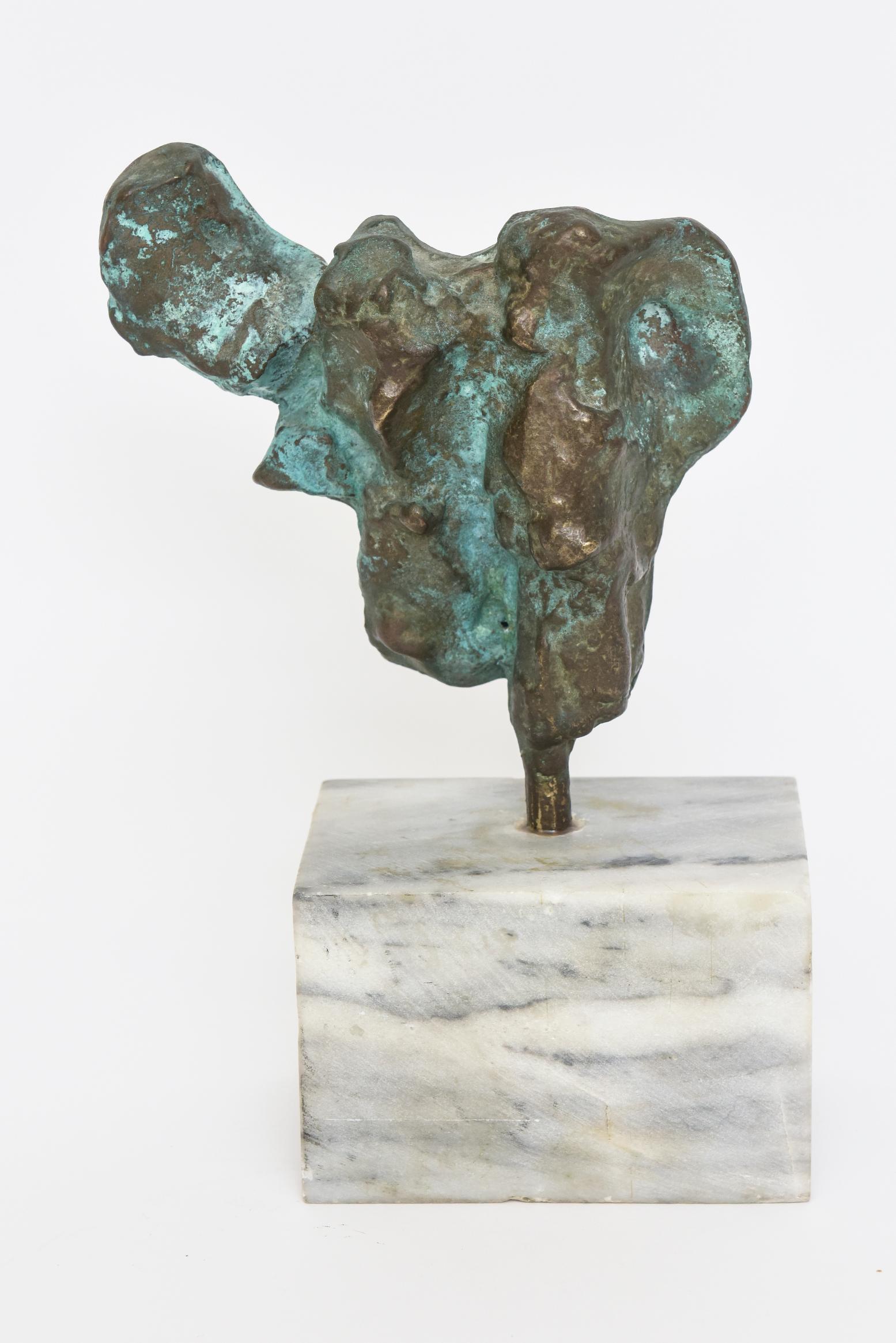 This wonderful abstract unsigned tabletop vintage bronze sculpture has a beautiful verdigris patina on the surface in turquoise and bronze color. It sits on the original white and gray Carrara marble base which we will just got polished out now