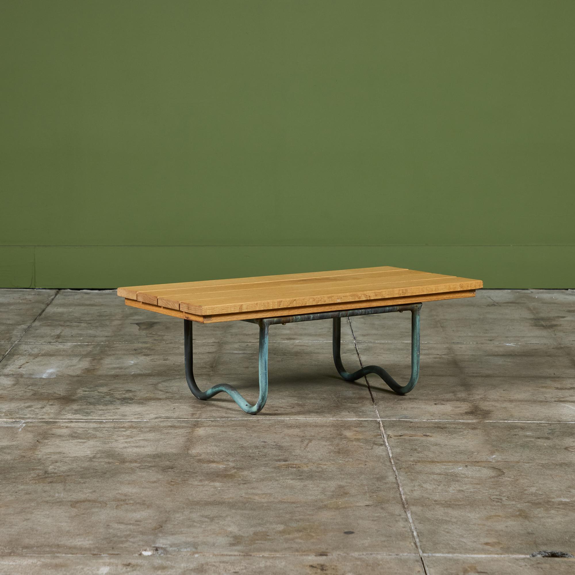 La table de plage WT-3715, conçue par Walter Lamb pour Brown Jordan, est dotée d'une structure tubulaire en bronze et d'un plateau en lattes de bois de chêne neuf. Rappelant les travaux antérieurs de Lamb, la table présente des courbes moulées dans