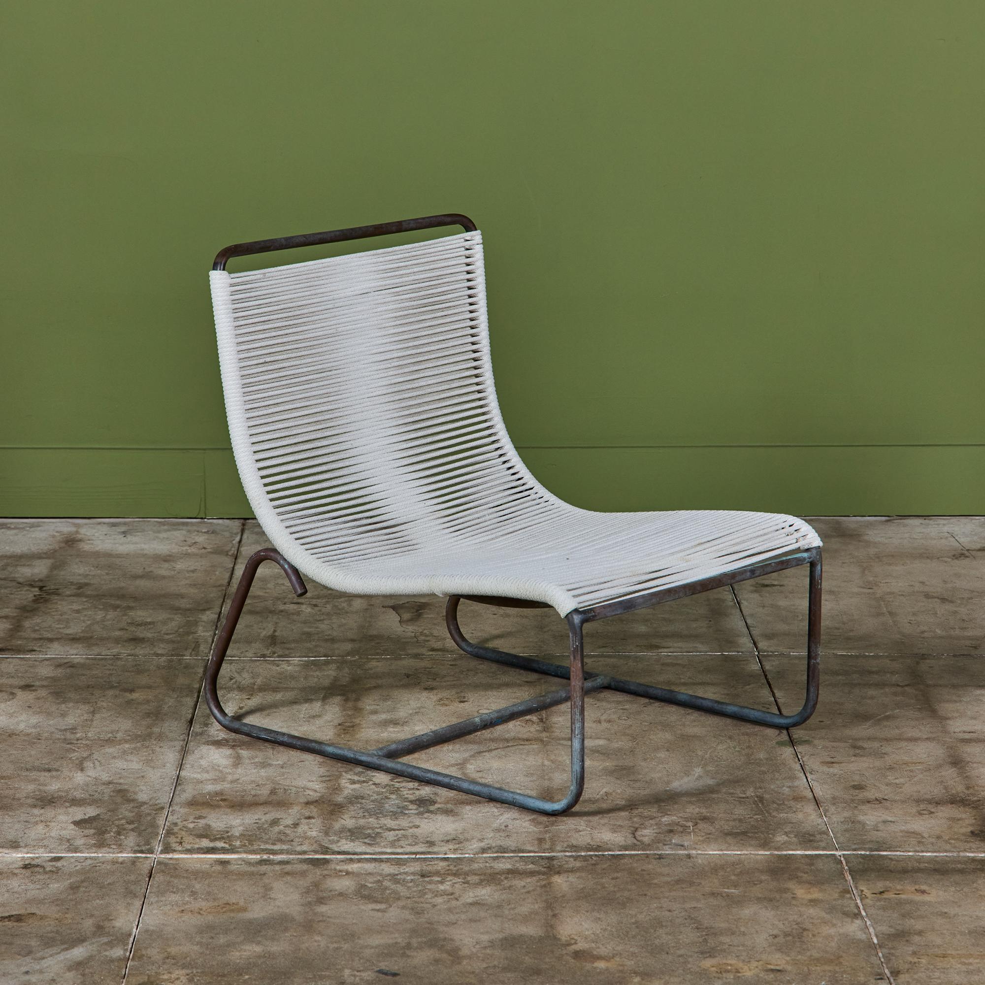 A low lounge chair, known as the “Sleigh Chair,” by Walter Lamb for Brown Jordan. A continuous length of tubular bronze serves as the frame of a scooped seat, bends beneath the chair to form two runners. A curved support bar stretches below the