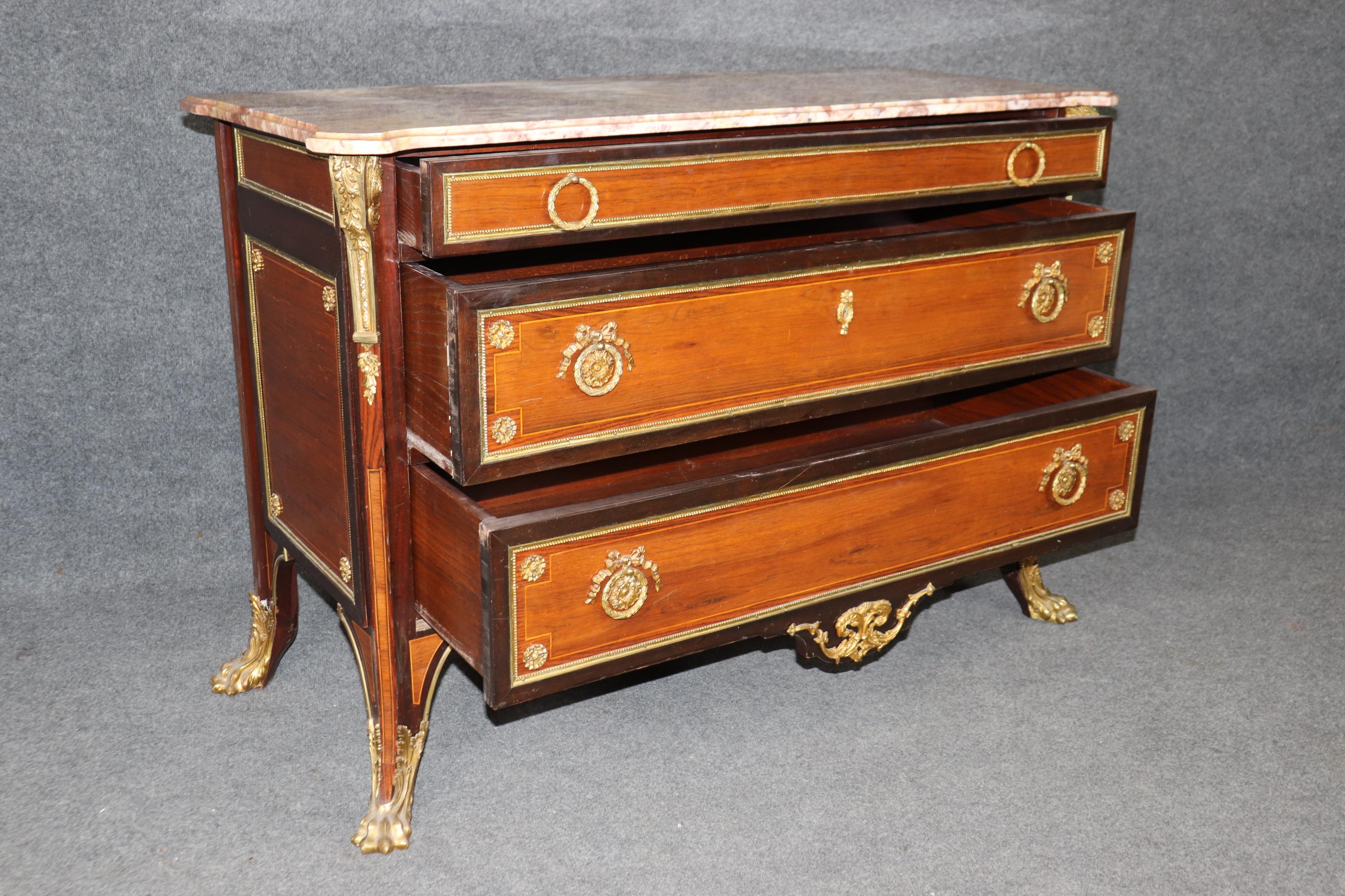 Si tratta di una fantastica commode montata in bronzo con alcuni degli elementi più robusti e sapientemente fusi che abbiamo visto da molto tempo a questa parte. I cassetti in palissandro contrastano meravigliosamente con la cassa in mogano più