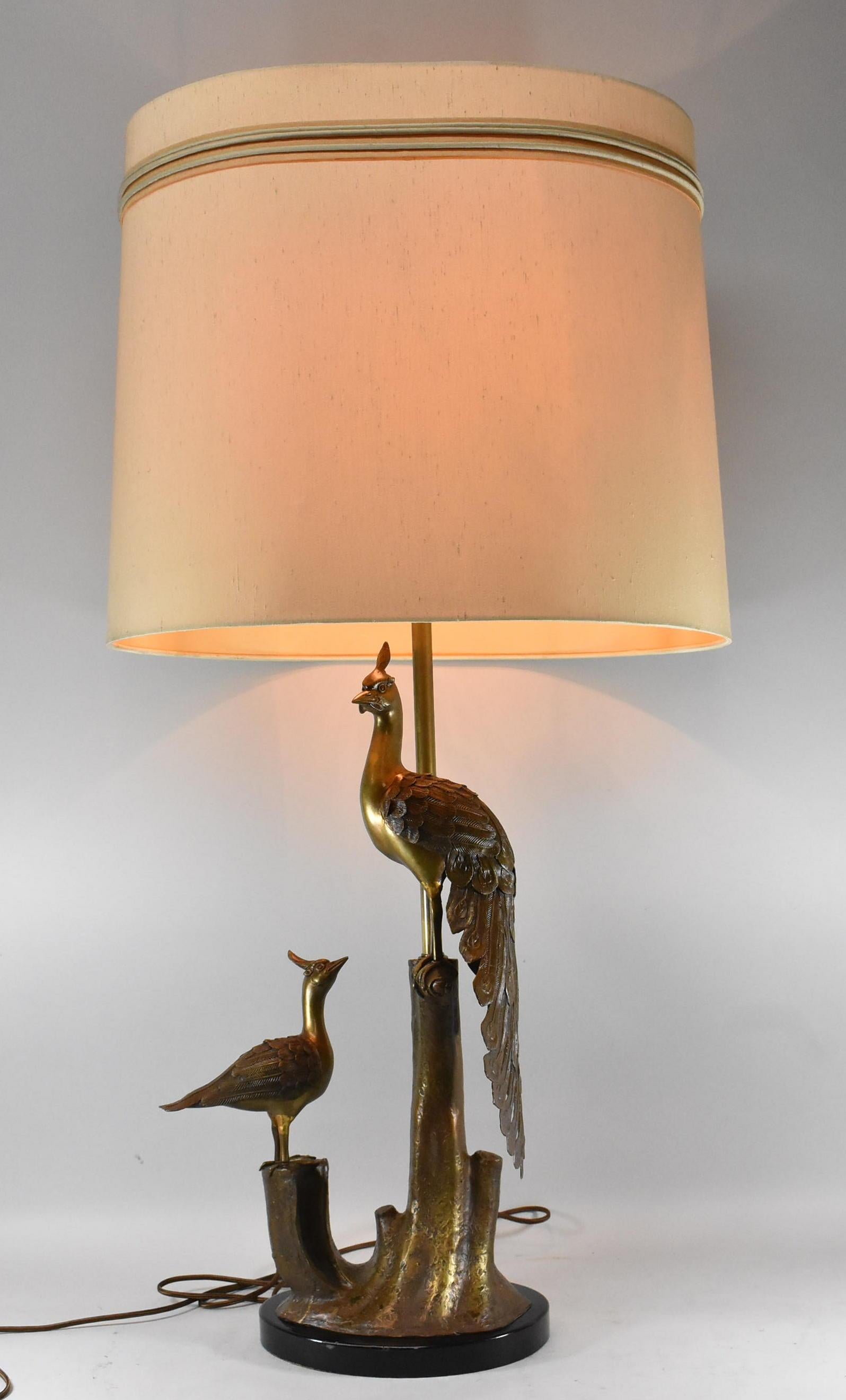Lampe de table en bronze représentant deux paons assis sur une souche d'arbre. Les plumes et l'écorce d'arbre sont magnifiquement texturées. La lampe est recâblée. L'abat-jour n'est pas inclus.