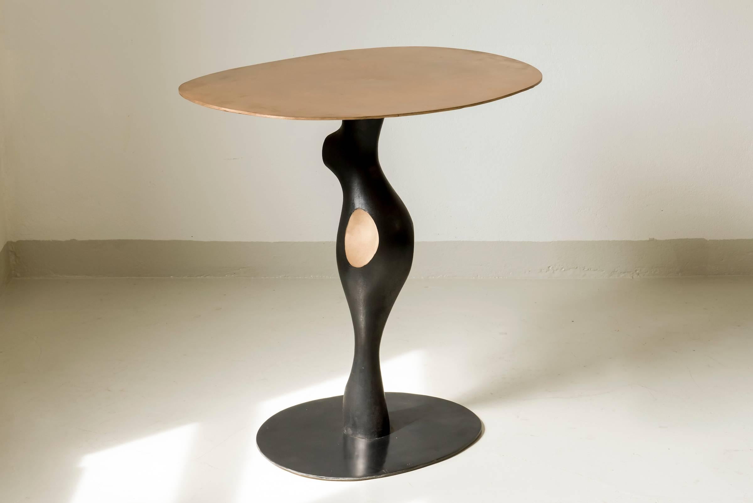 This sculpture/ gueridon or pedestal table was created by Jacques Jarrige in 2017. He sculpted it in wood then sand casted it in bronze. This sculpture table seems to be in movement.
The base has a black patina, the central has a black patina with