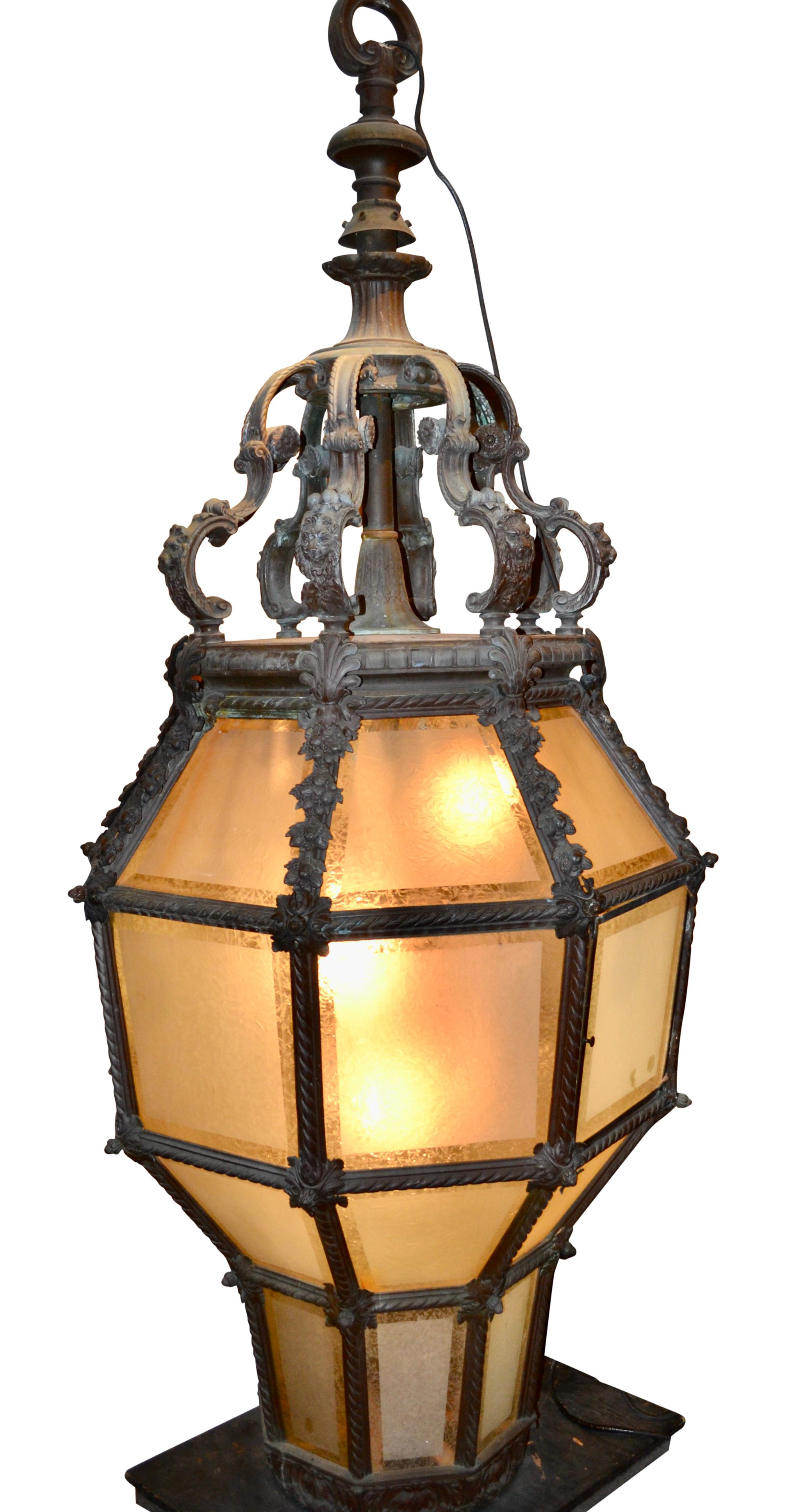 A monumental cast bronze and frosted glass porte cochere lantern; (a porte cochere is a roofed structure extending from the entrance of a building over an adjacent driveway and sheltering those getting in or out of vehicles). This example was likely