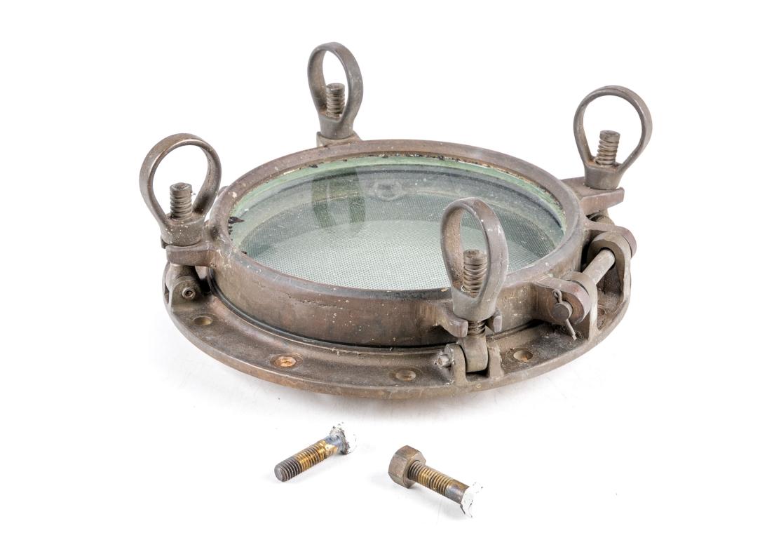 Hublot en bronze de l'ère industrielle Avec un bon poids, un couvercle en verre avec écran et des chiens de trappe en état de marche. Il y a deux boulons en bronze qui l'accompagnent. Le bronze présente une belle patine d'ancienneté et une belle