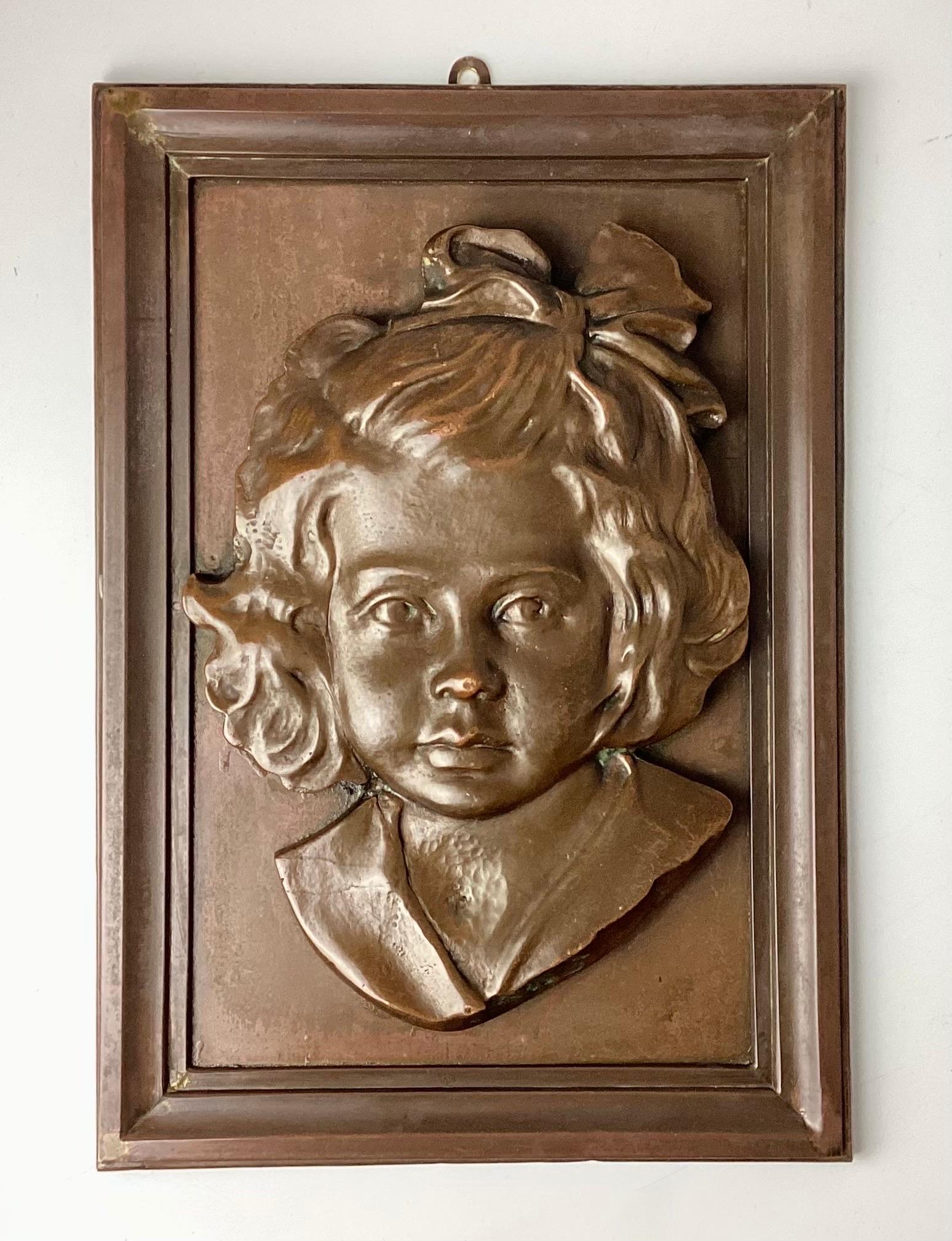 Bronze Portrait Plaque of a Young Girl. She is made of bronze and mounted on a bronze frame. No markings. Well done. Hook was added and not included in measurements.