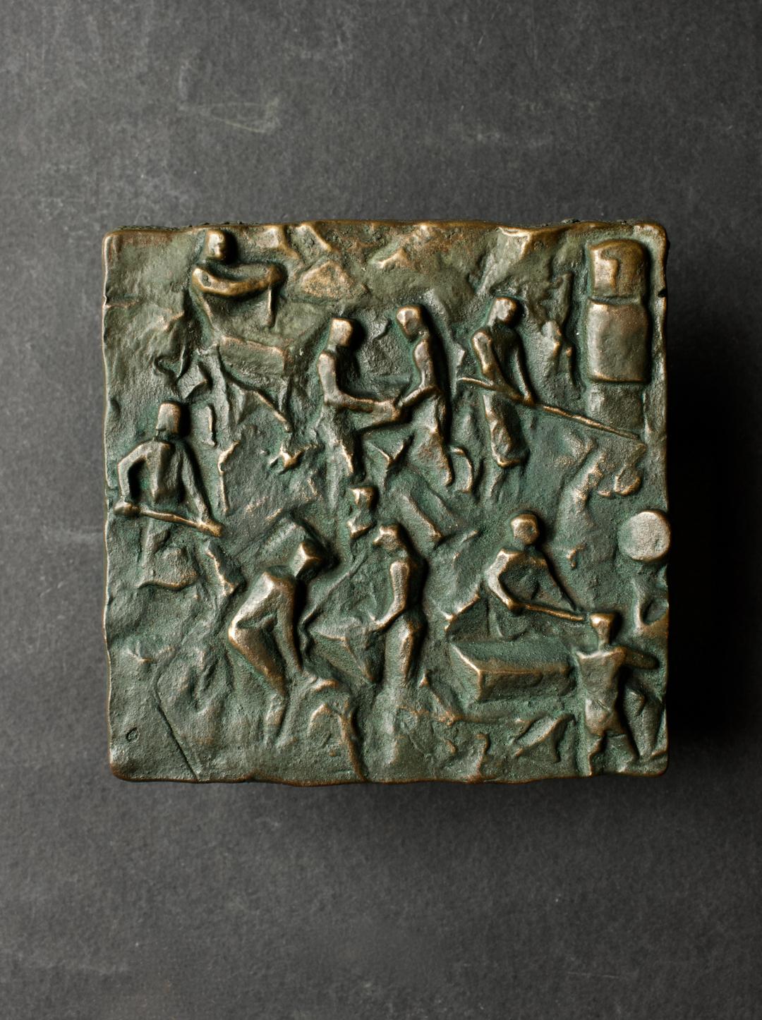 A large sculptural bronze push-pull door handle, of square form with raised semi-abstract design depicting craftsmen at work. Mid-20th century, European. 

A heavy piece, made of cast bronze with changing tones from use; we have not polished this