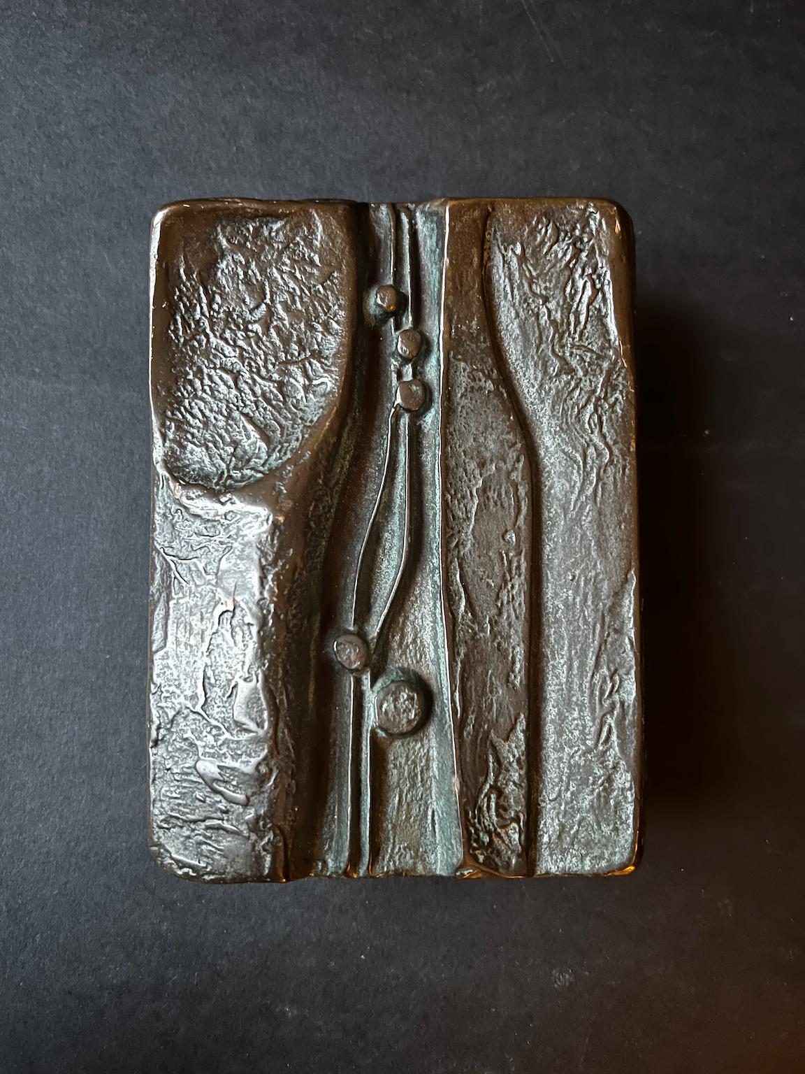 Manilla de bronce fundido con diseño abstracto en relieve. De mediados a finales del siglo XX, encontrada en Alemania.

Una bonita pieza pesada con una pátina oscura aplicada. Presenta signos de desgaste, como manchas brillantes a lo largo de los