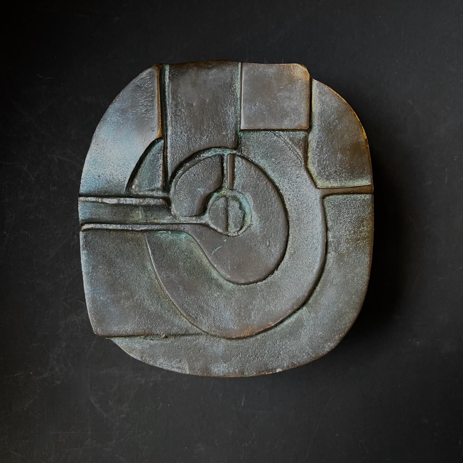 A heavy push-or-pull door handle made of cast bronze featuring a raised abstract pattern and texturing to the edges and bracket. 20th century design, found in Germany.

The piece is in good vintage condition with a dark brown/green patina to the