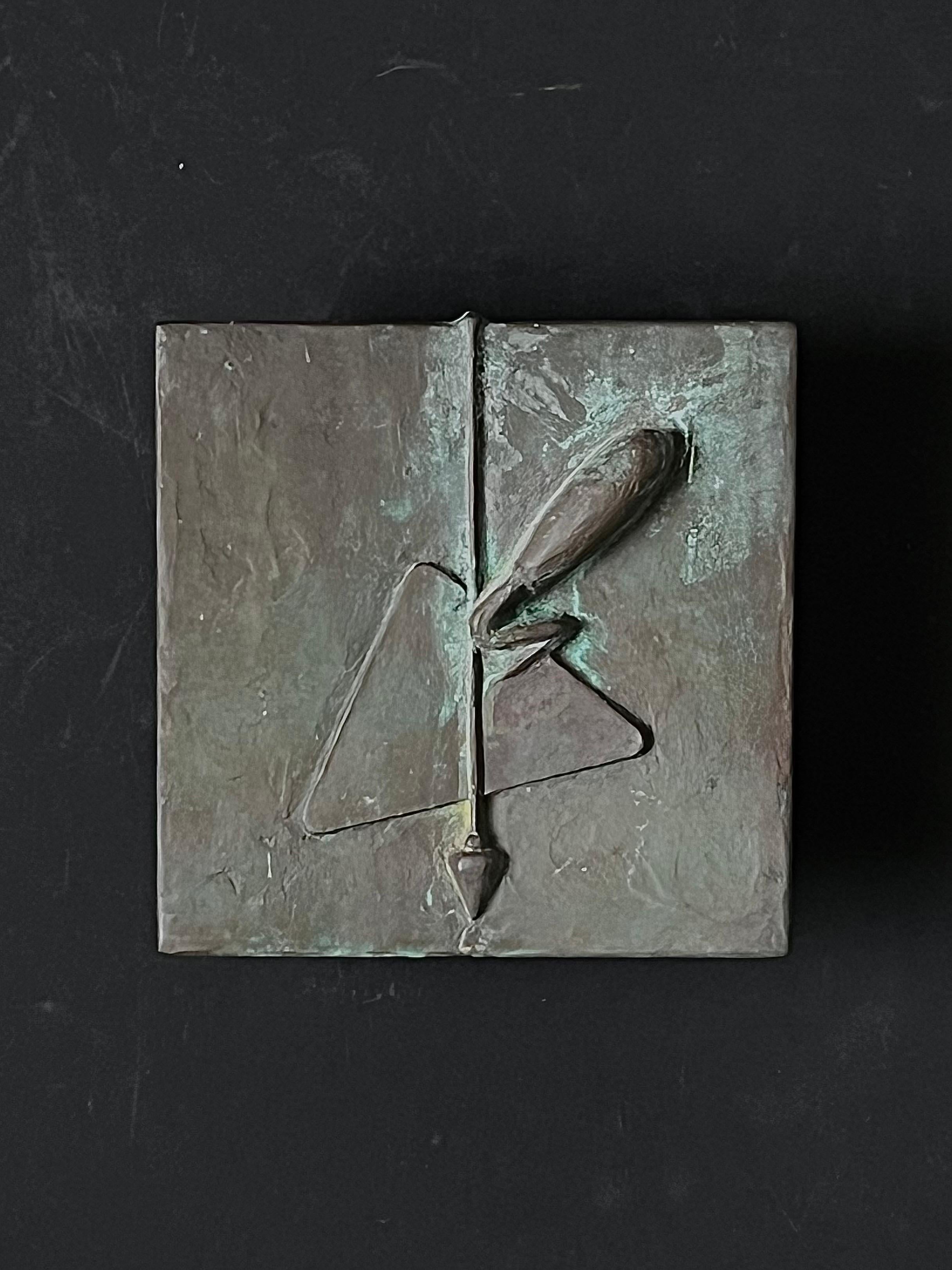 A square push-pull door handle made of bronze featuring a raised design of simple architectural tools. 20th century design, found in Germany.

The piece is in good vintage condition with a dark brown colour to the metal. There are signs of wear in