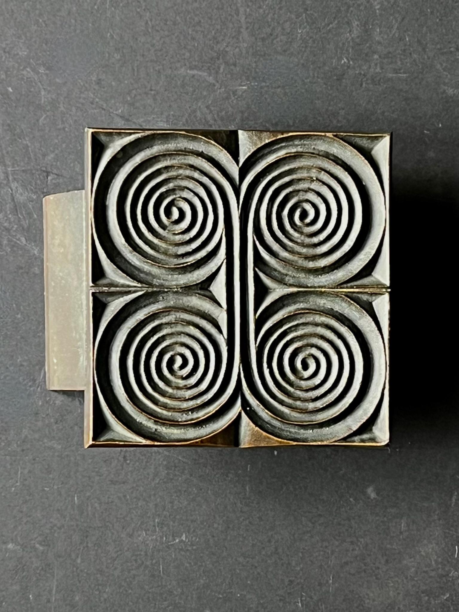 Viereckiger Türdrücker aus Bronzeguss mit erhabenem Spiralmuster. Design aus dem 20. Jahrhundert, gefunden in Deutschland.

Das Stück ist in gutem Vintage-Zustand mit einer dunkelbraunen Patina auf dem Metall. Es gibt alters- und gebrauchsbedingte