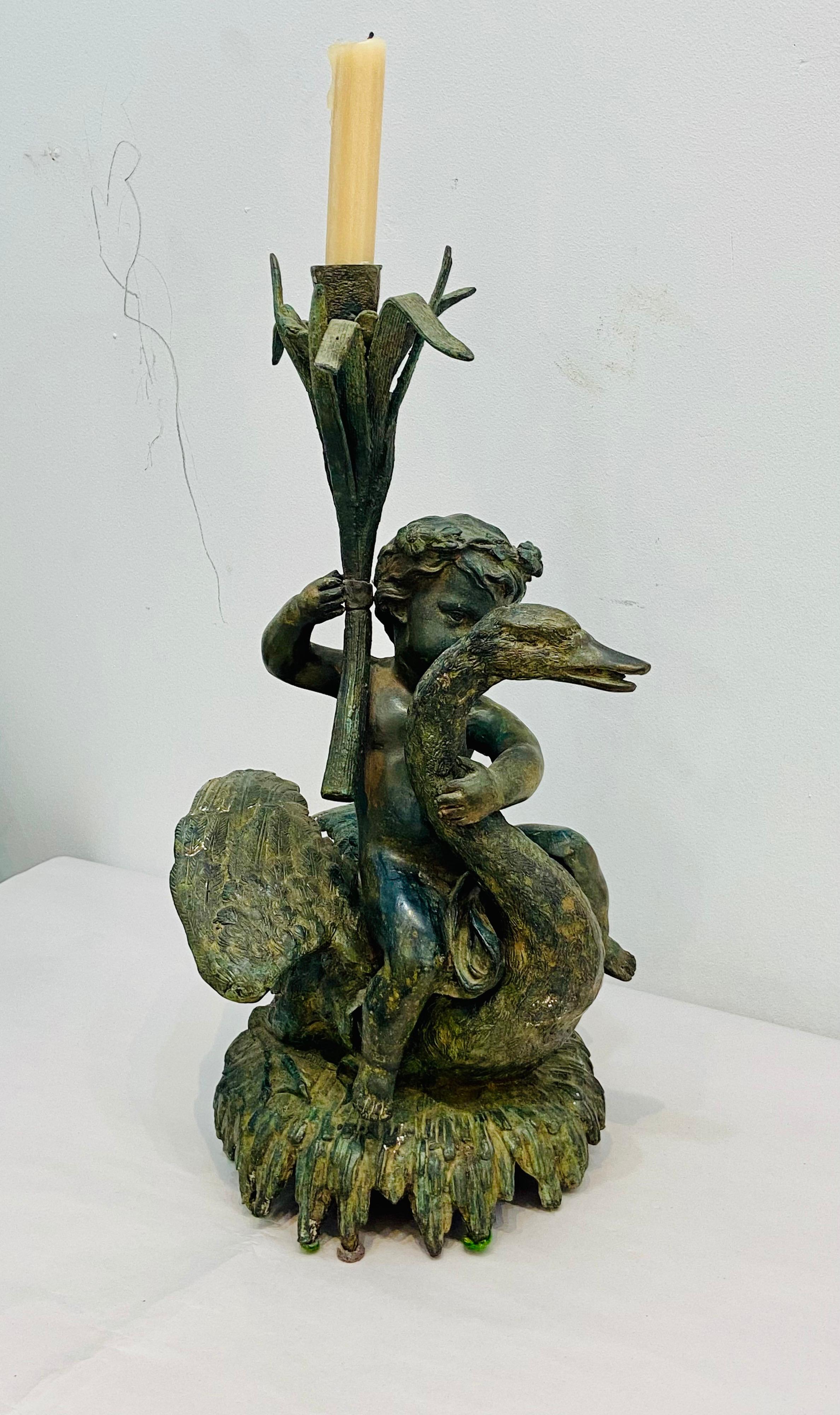 Bronze Statue of a angelic boy riding a swan. Angel is holding aloft a candlestick. Would make a nice accent piece for an outdoor get together. Probably Maitland Smith from the 1980s.