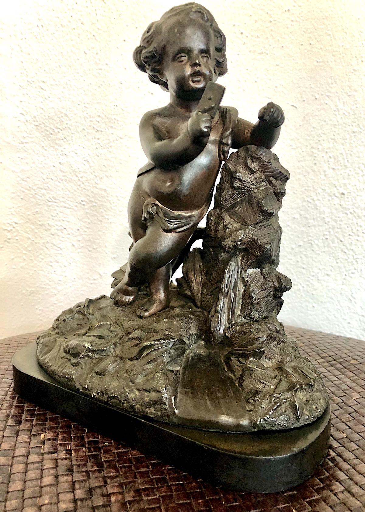 Let’s get this cleared up right now: No, he’s not holding a cell phone. Instead, this little fellow is doing the job he was created to do, namely providing a place to hang a pocket watch when not on the person of the owner. As a figural bronze