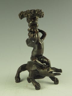 Bronze-Kerzenständer aus Krokodil, Putto reitend