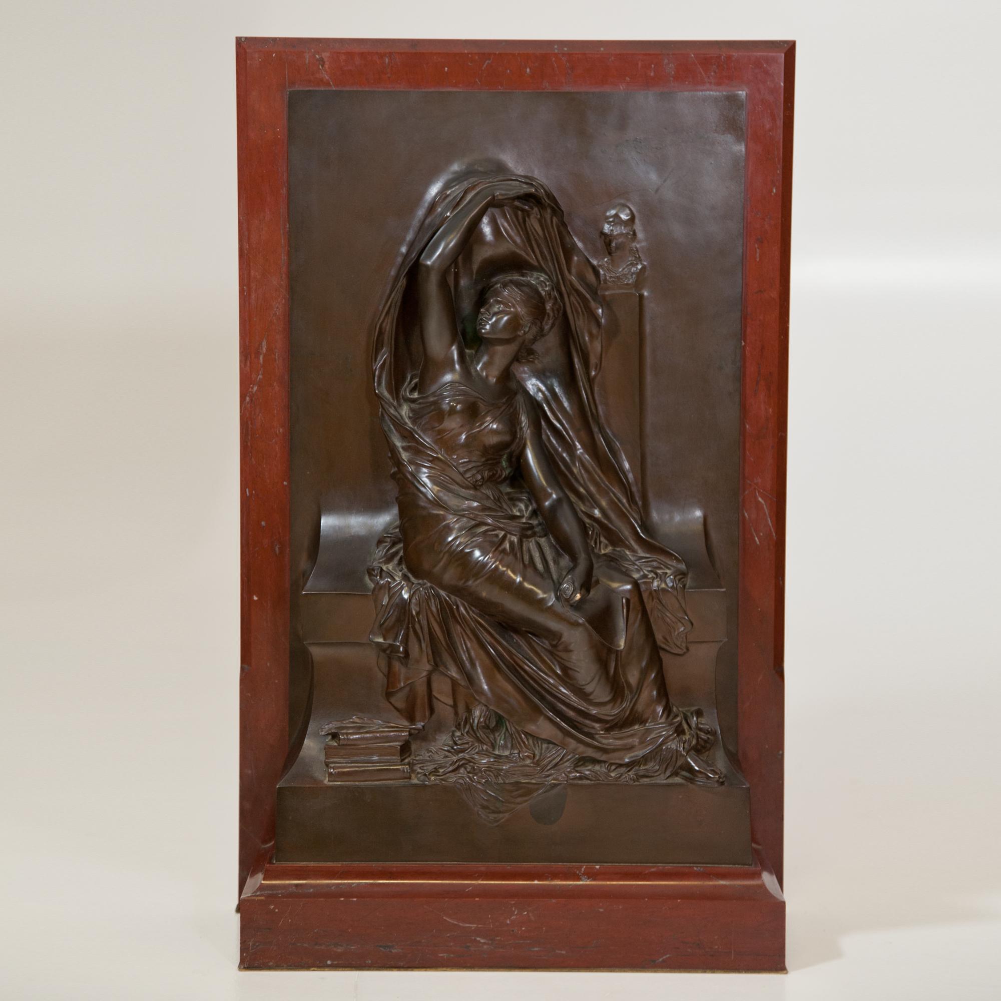 Bronze relief on red marble, signed H. Chapu and foundry stamp of Thiébaut Frères Fondeurs at the side. Depiction of a sitting young lady with a bust of Athena in the background.
