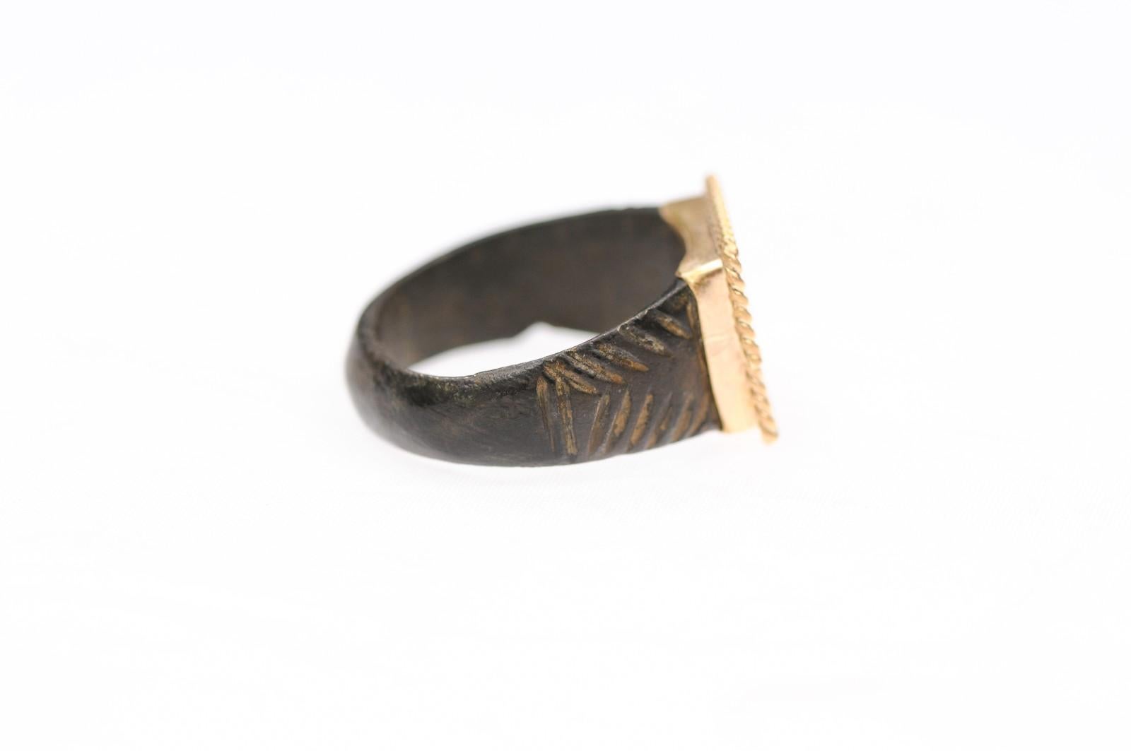 Un formidabile anello in bronzo risalente all'Impero Romano, tra il IV e il VI secolo circa, con accattivanti rifiniture in stile corda in oro a 21 carati. Questo anello con motivo geometrico è perfetto per un uomo o una donna e può essere indossato
