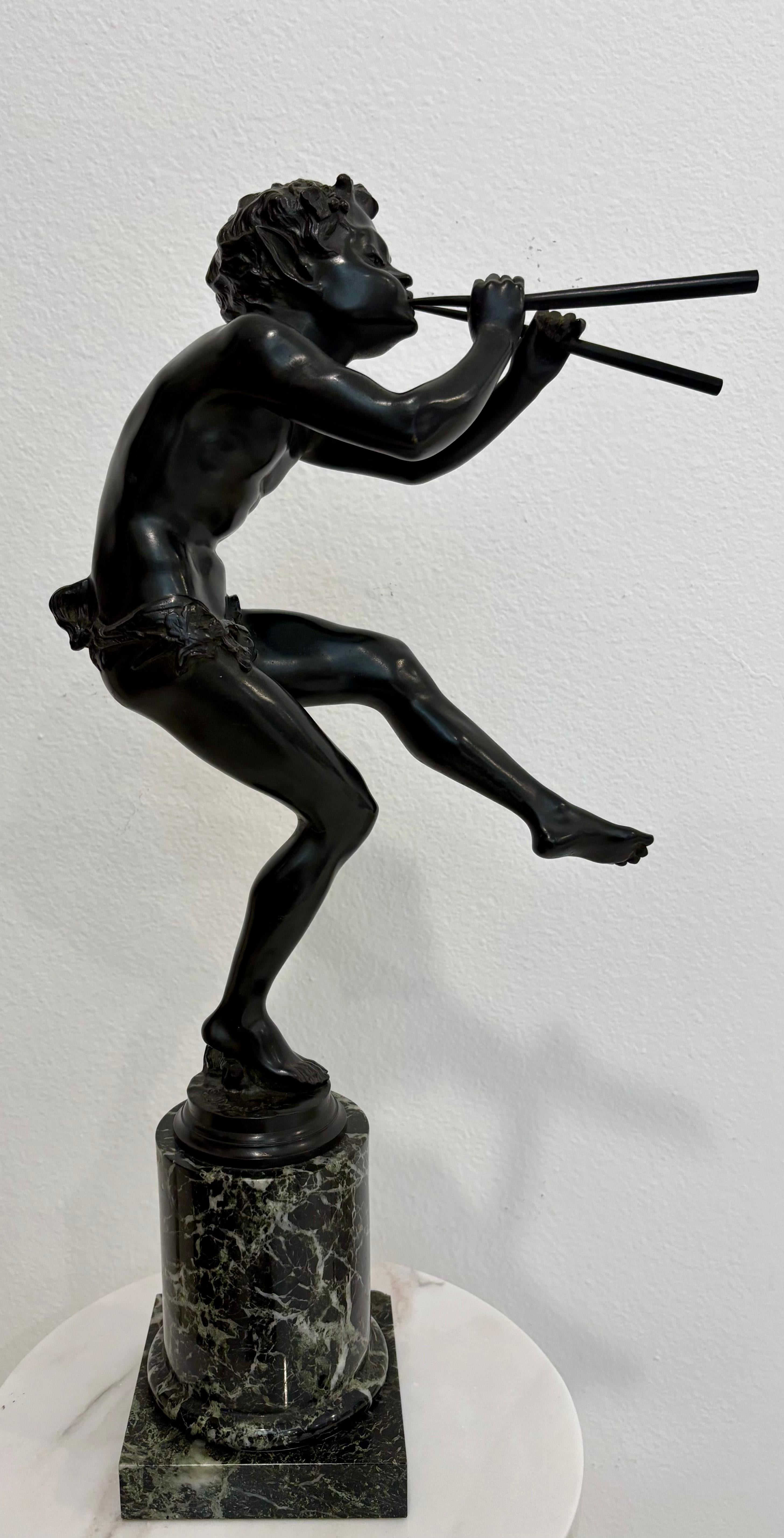 Questa sorprendente scultura in bronzo dell'acclamato artista francese Edouard Drouot (1859-1945) raffigura una spiritosa figura di satiro in movimento, che suona un paio di pipe con esuberante energia. Fusa in bronzo patinato scuro, la posa