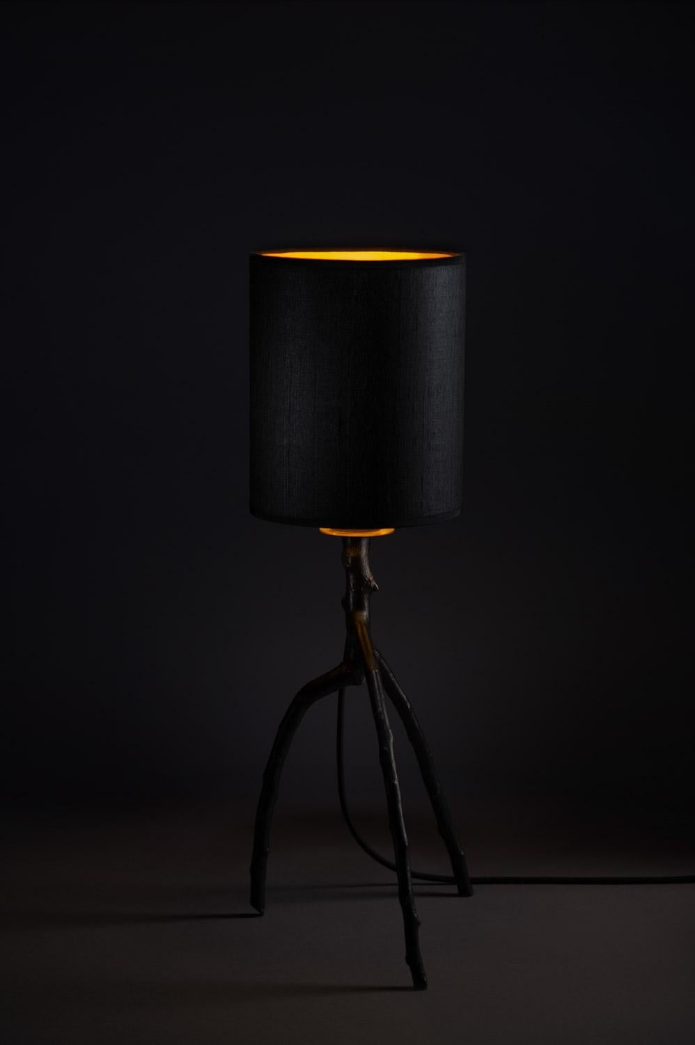 This handcrafted bronze table lamp is made in France. With an apple tree branch in black polished bronze as leg, a lampshade in handmade black silk with interior gold, a brass plate, a switch with its black cable, this lamp belongs to the Bronze