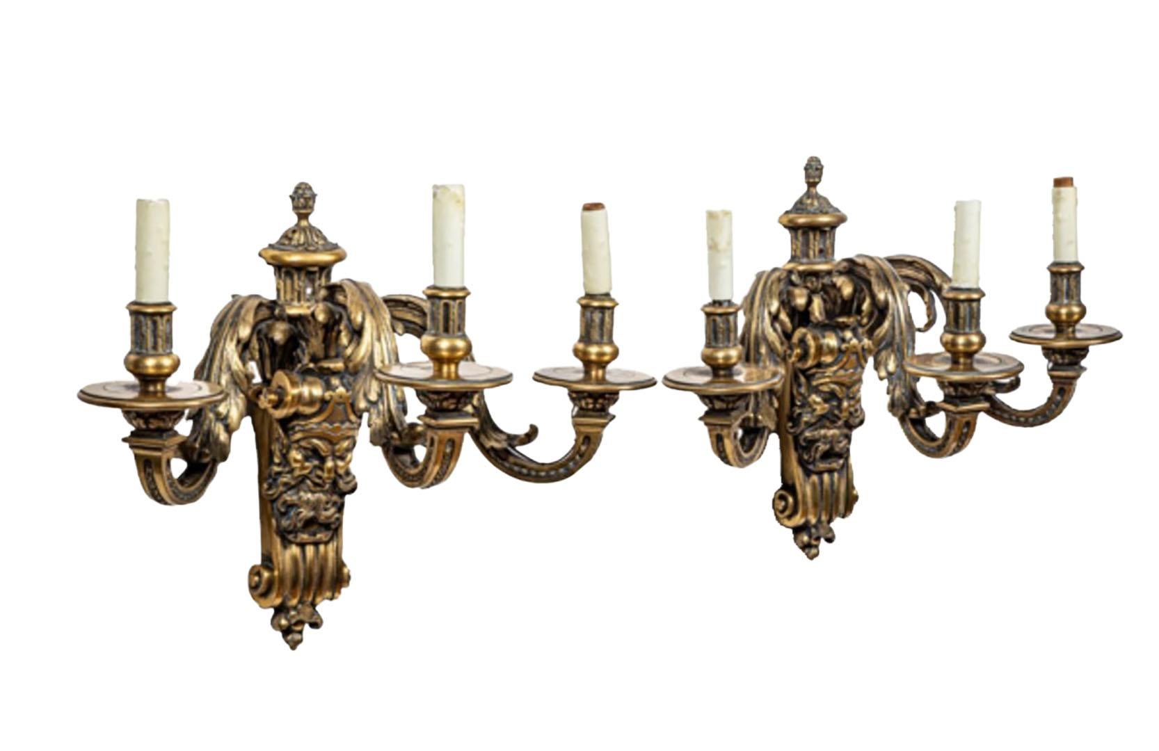 Raffinata coppia di appliques continentali a tre luci in bronzo con maschere di Bacco e  braccia foliate. Circa 1840.
