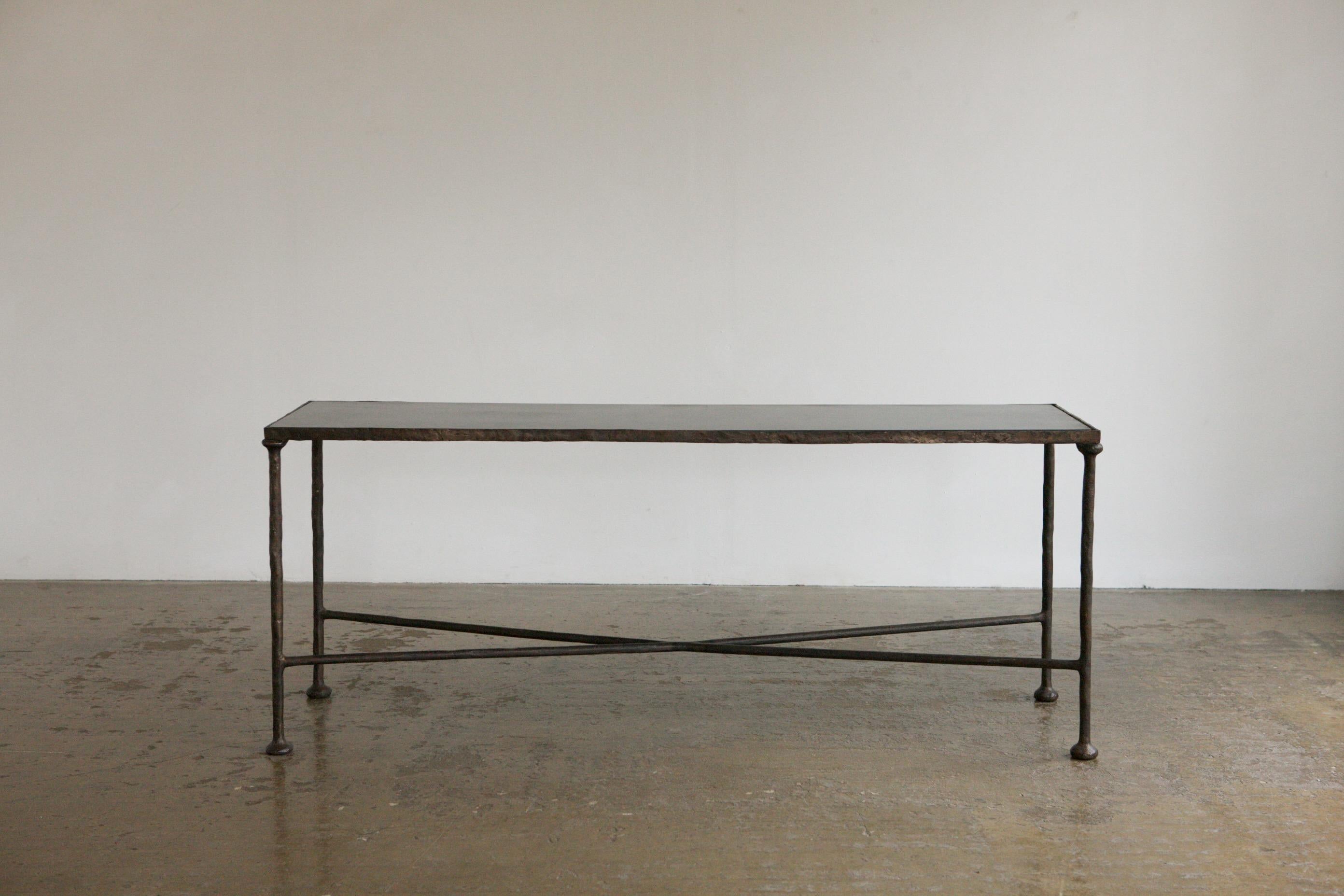 An absolutely incredible console in solid bronze with a black steel table top. The table which has had a steel top inserted is made in the matter of the work of Diego Giacometti, brother of Alberto Giacometti. Work in bronze is highly collectable.