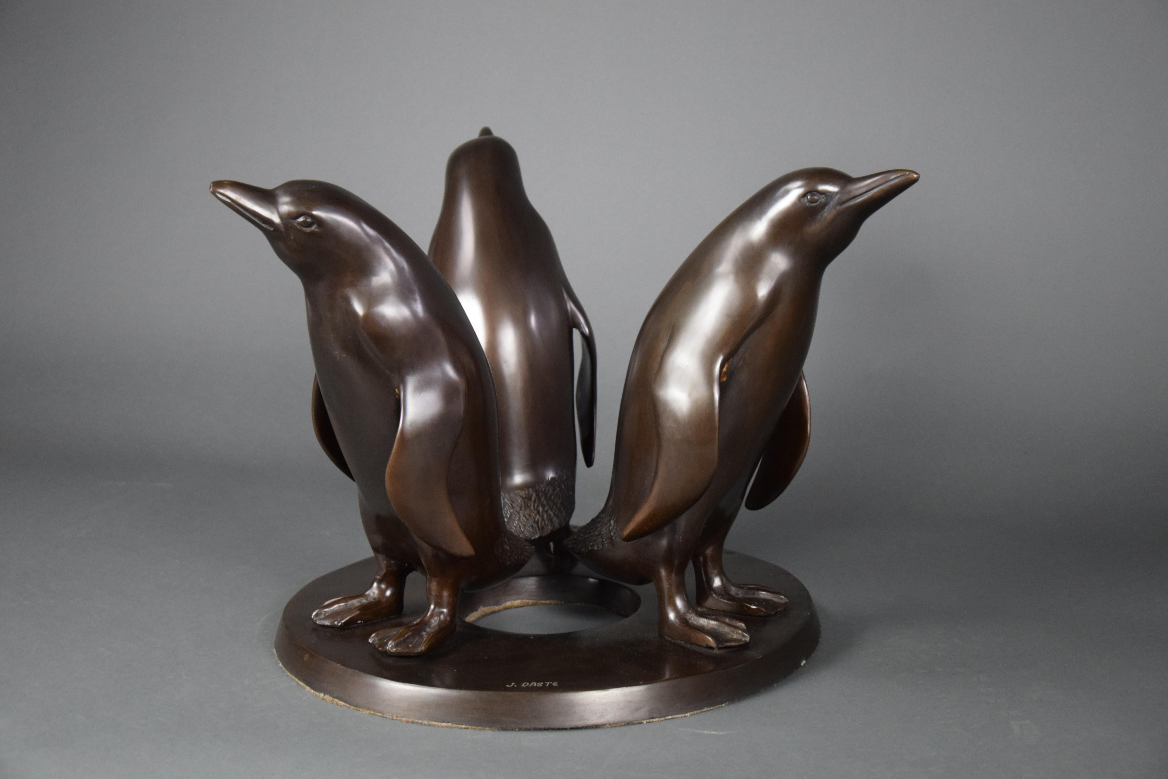 Experience the elegance of the 1920s with this one-of-a-kind sculptural bronze coffee table, crafted by the renowned artist Giuseppe d'Aste. The table features three beautifully executed bronze penguins that support a solid facet glass top, creating