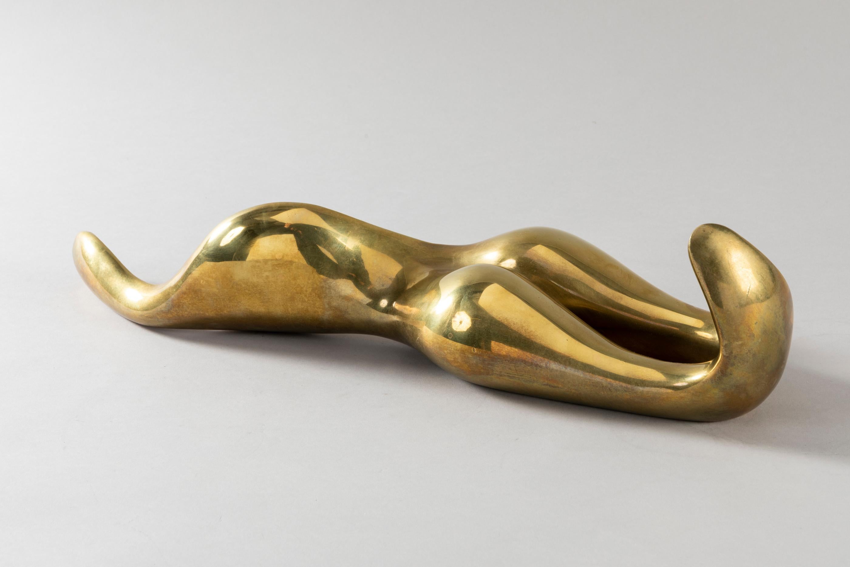 Cette sculpture sensuelle d'une femme allongée est réalisée en bronze à finition dorée. Il est signé A.R 1979. Fabriqué à la main dans la célèbre fonderie Valsuani.