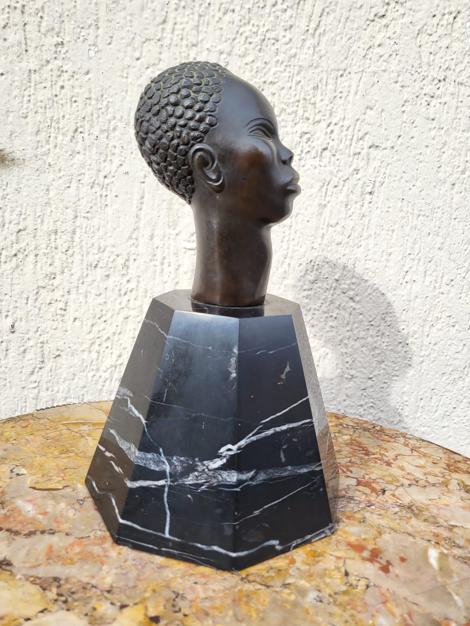 African head in bronze with black patina, on black and white marble base

Very good quality of carving and patina

Base with some wear and small chips of use

In the style of Riccardo Scarpa

Height 25cm (base only 13.5cm)
15 x 15cm