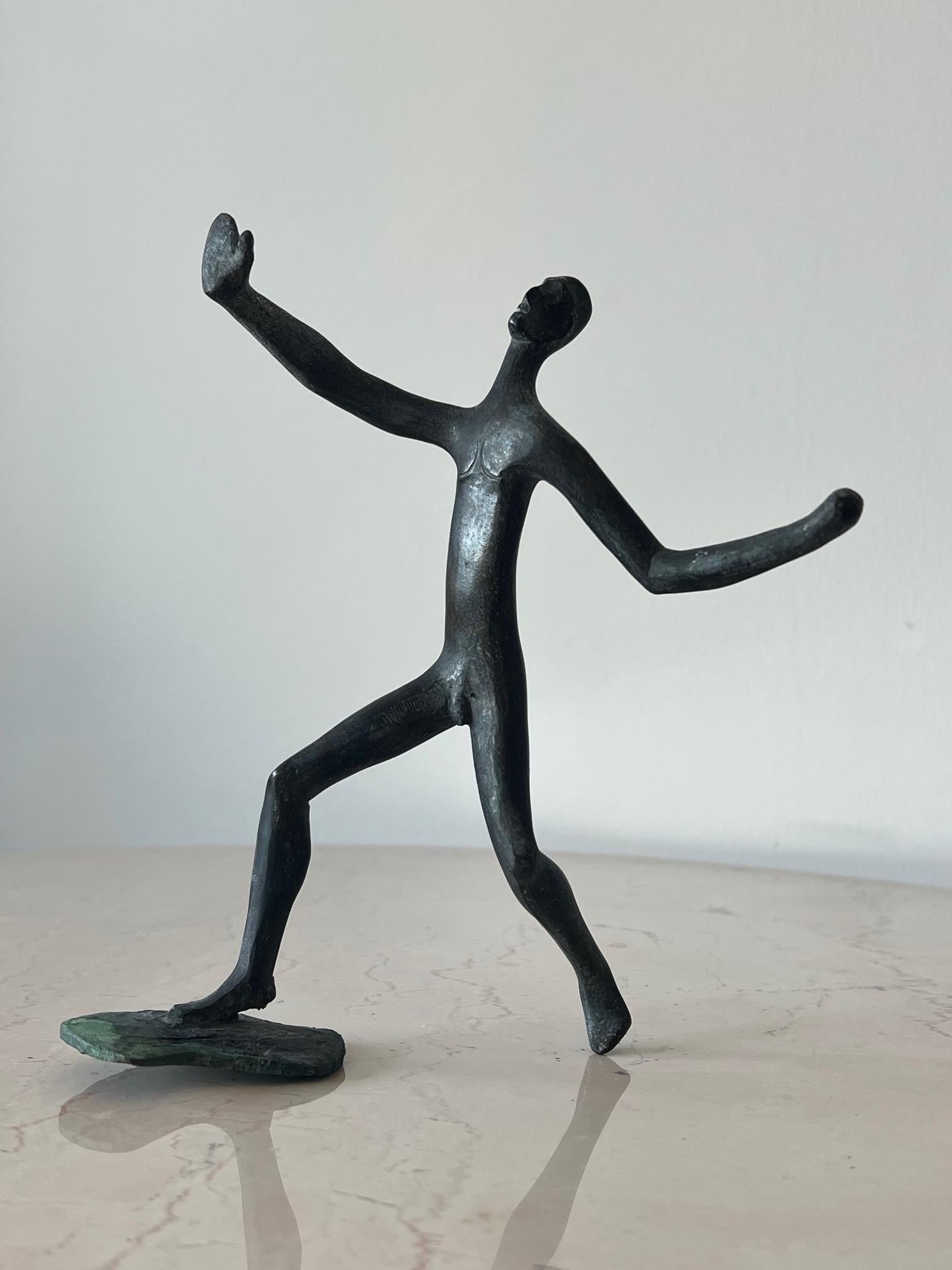 A unique, bronze sculpture of a man with outstretched hand, with timeless, Prehistoric feel by Anne Van Kleeck. From the artist's estate. A note about the artist: Anne Van Kleeck was primarily known for her works in cast bronze and ceramics. She